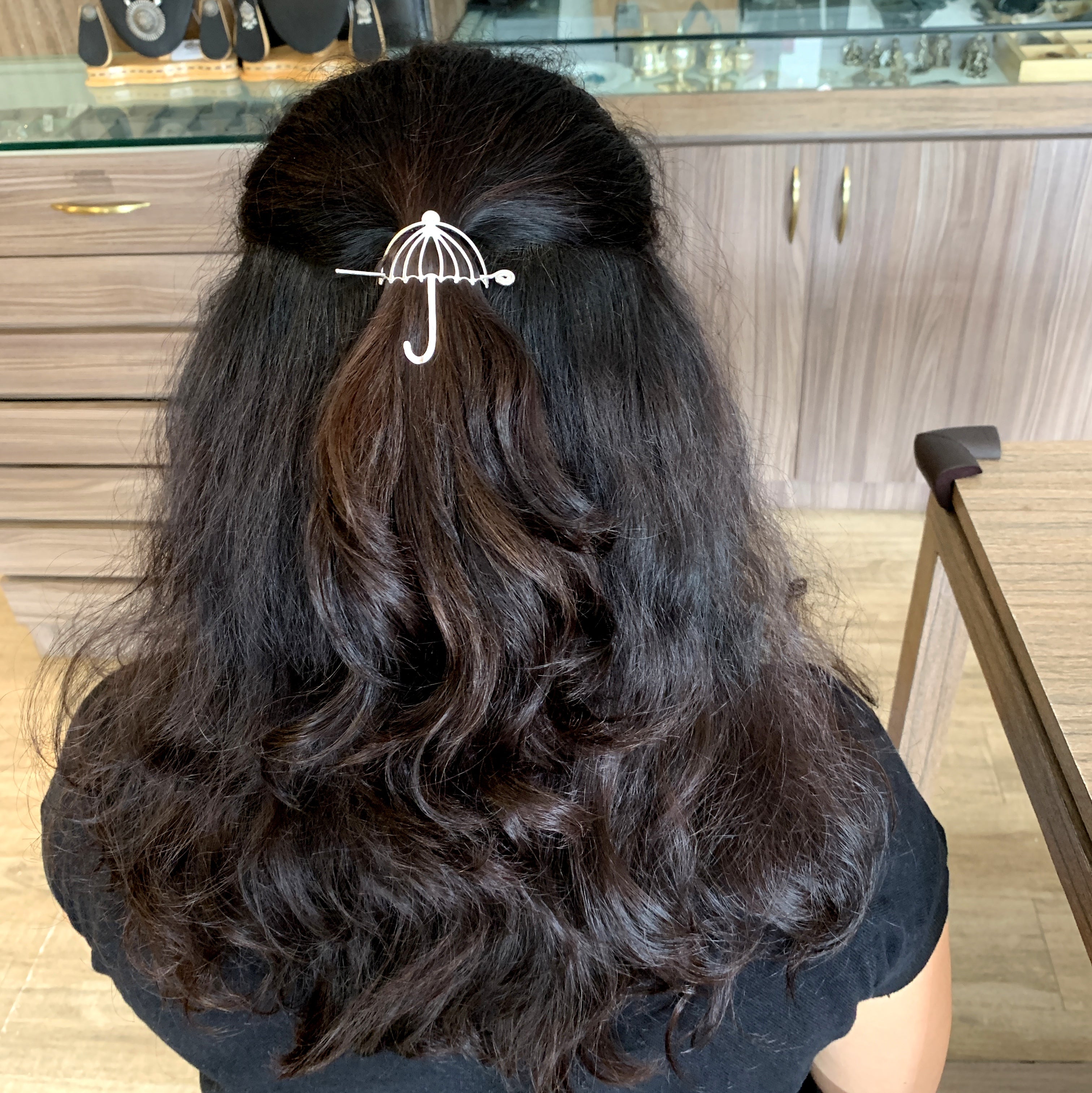 the back of a woman's head with an umbrella hair clip