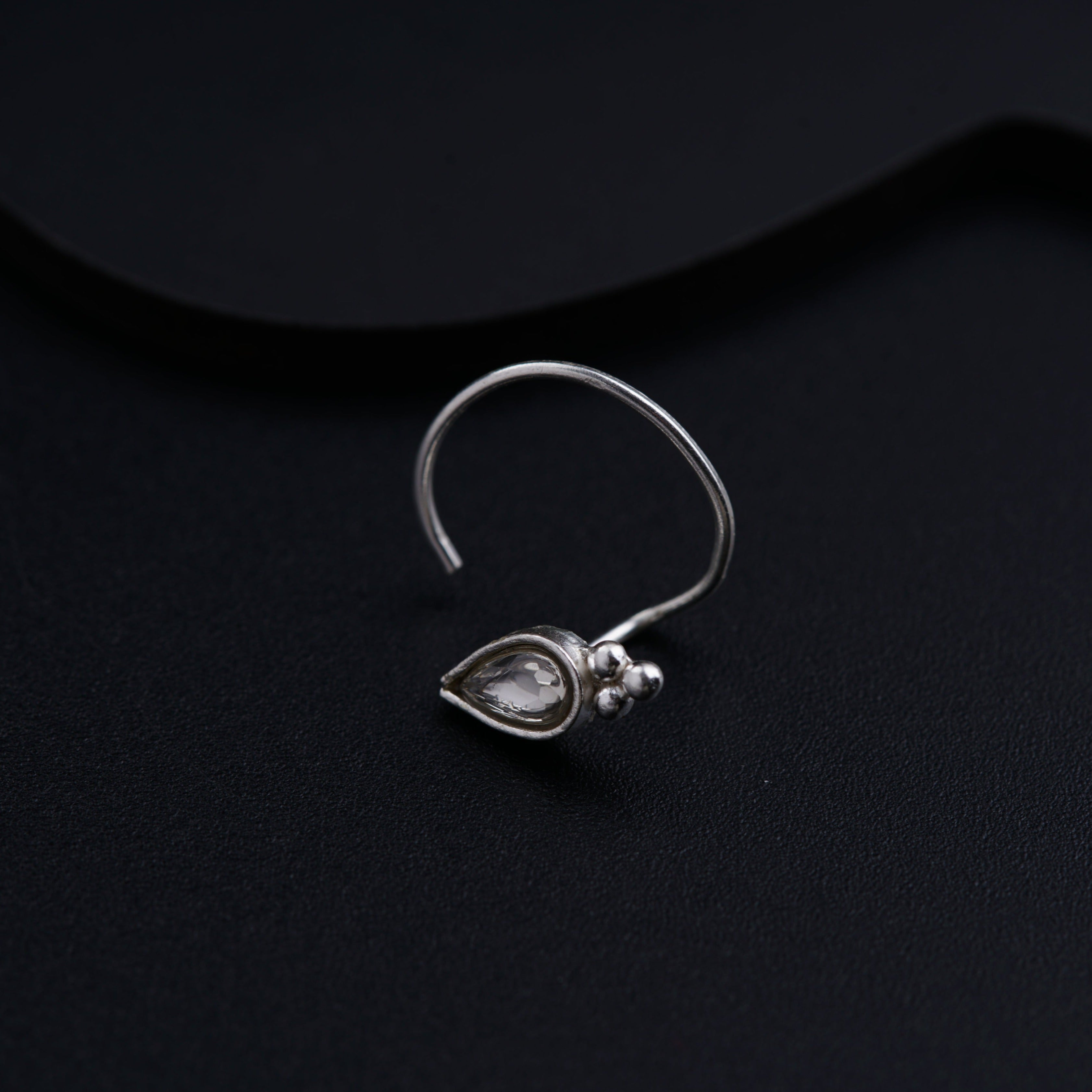 a close up of a pair of earrings on a black surface