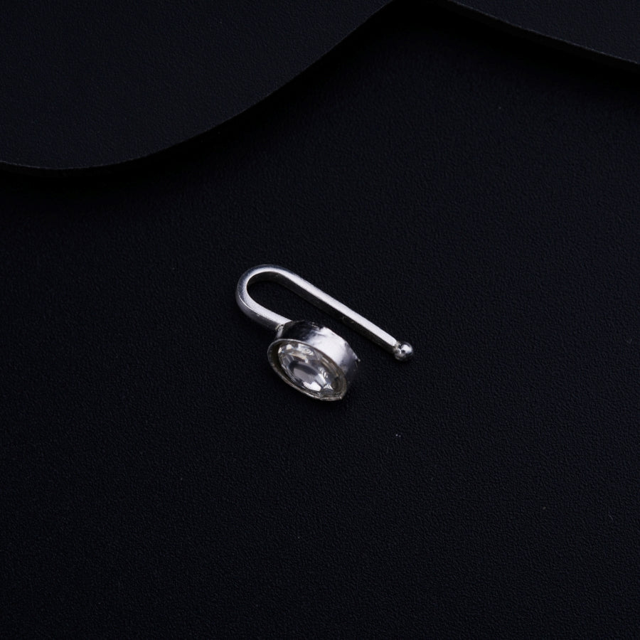 a pair of earrings sitting on top of a black surface