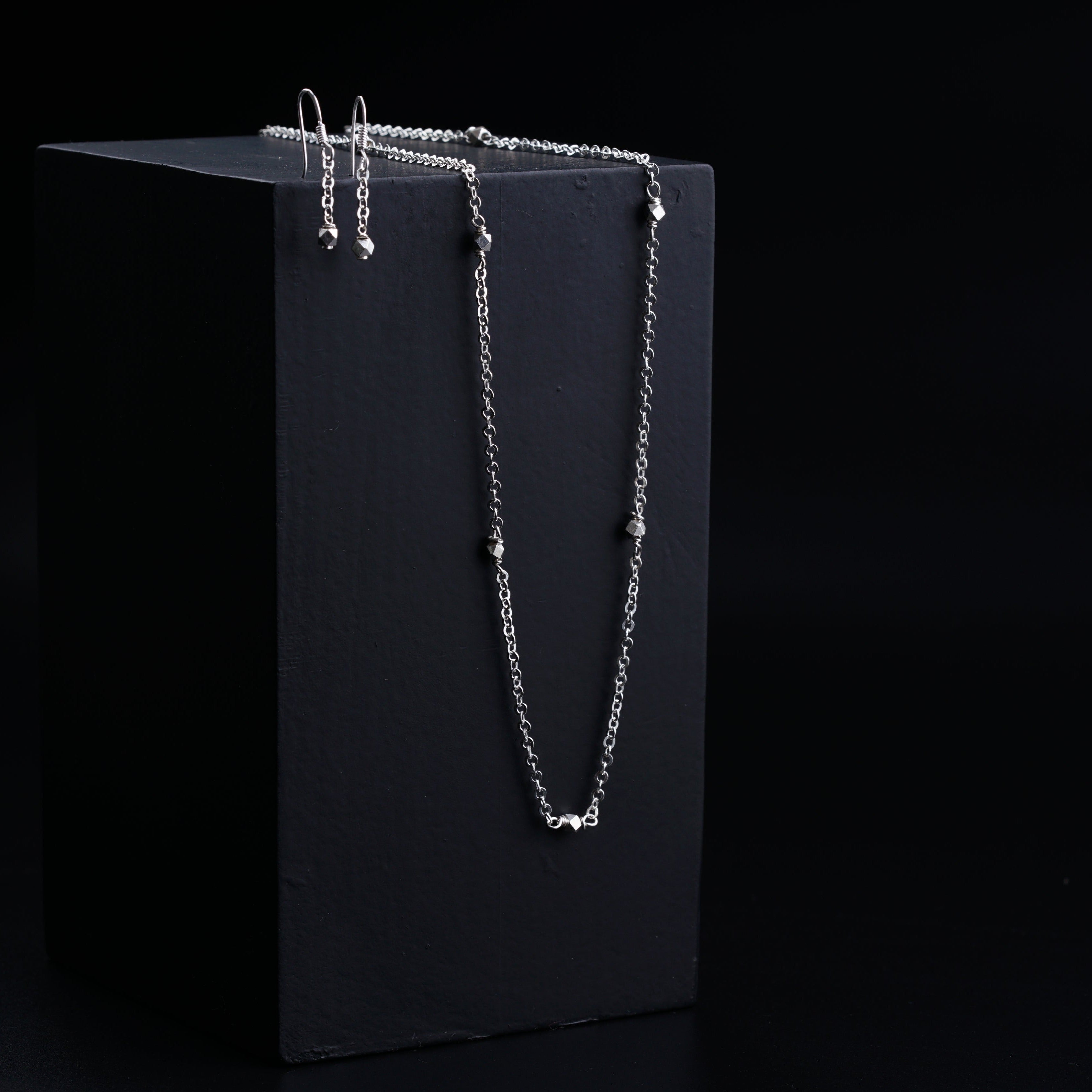 a black box with a silver necklace on it