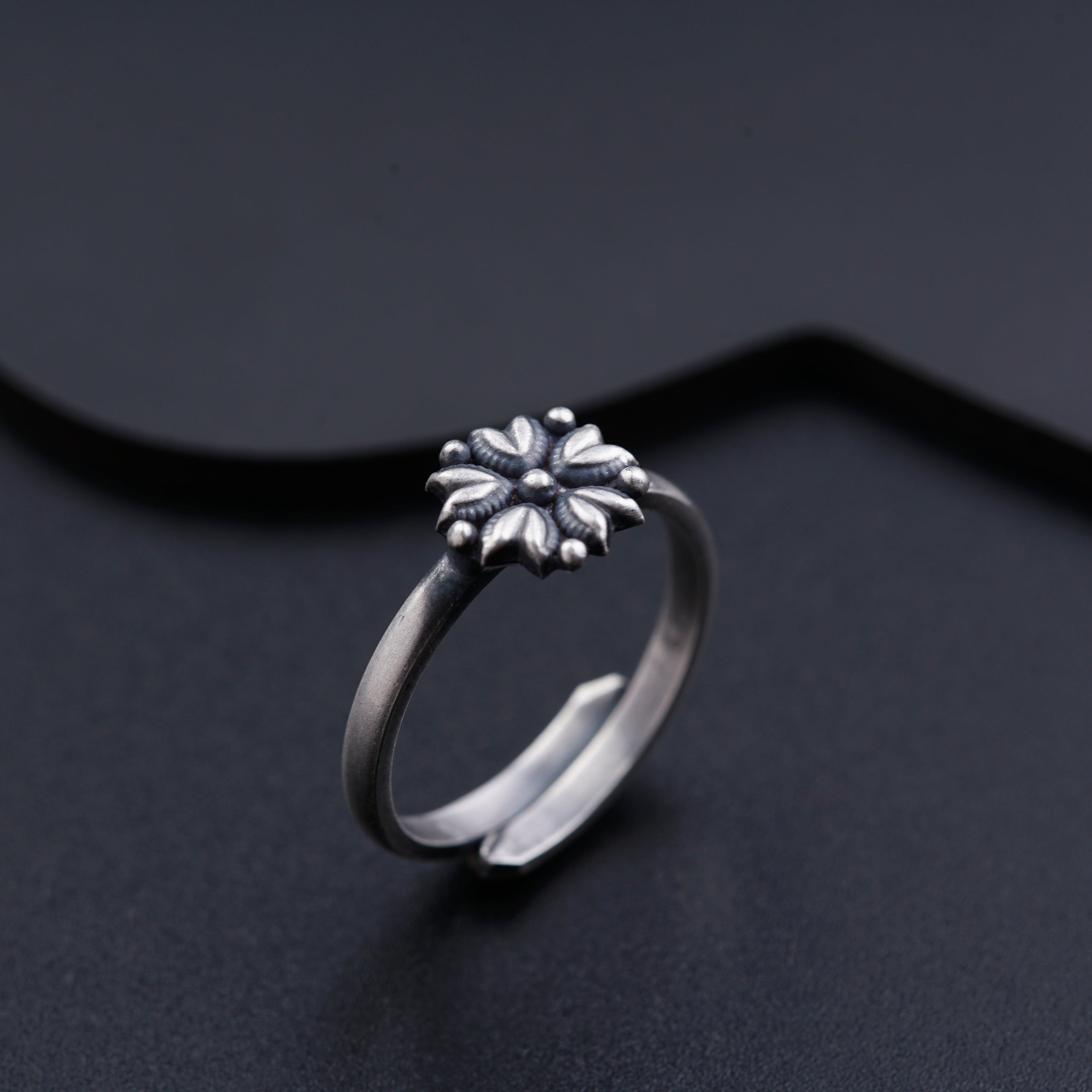 a silver ring with a flower on it