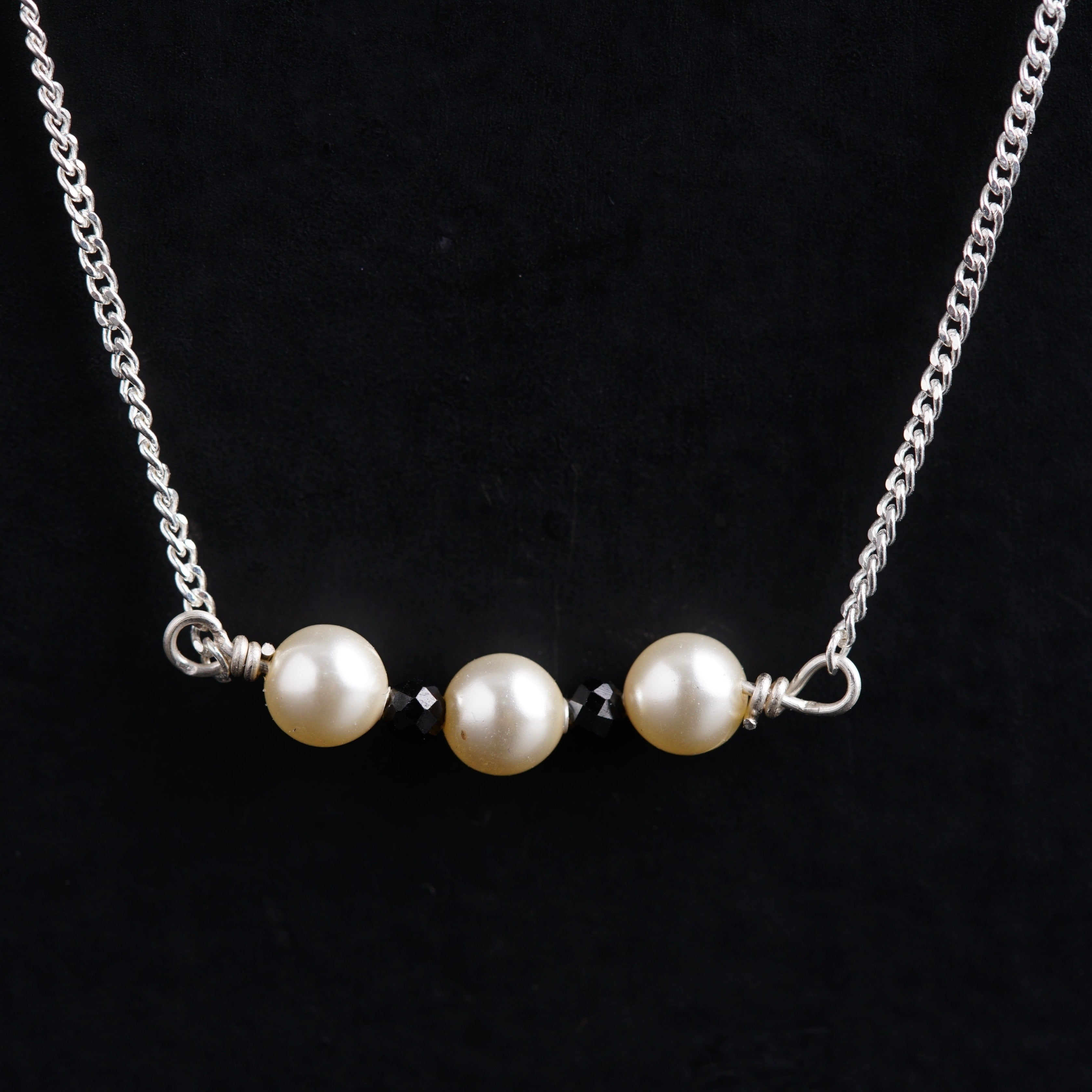a necklace with two pearls hanging from it