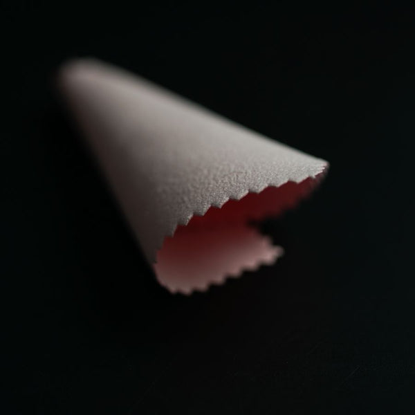 a close up of a piece of paper on a black surface