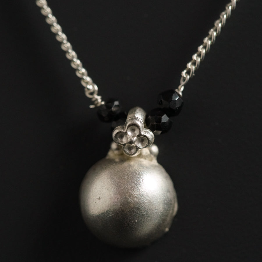 a silver necklace with a skull on it