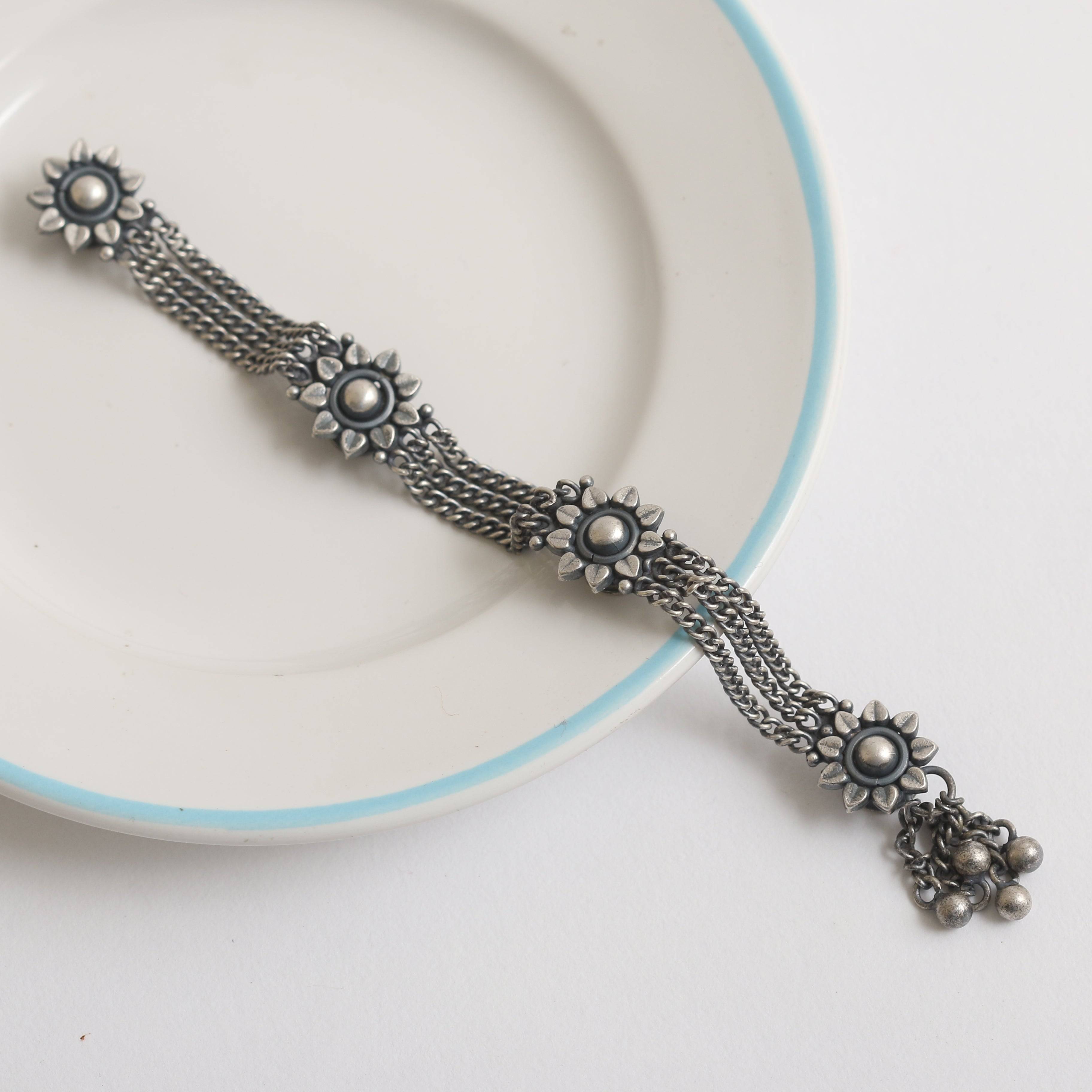 a white plate topped with a metal bracelet