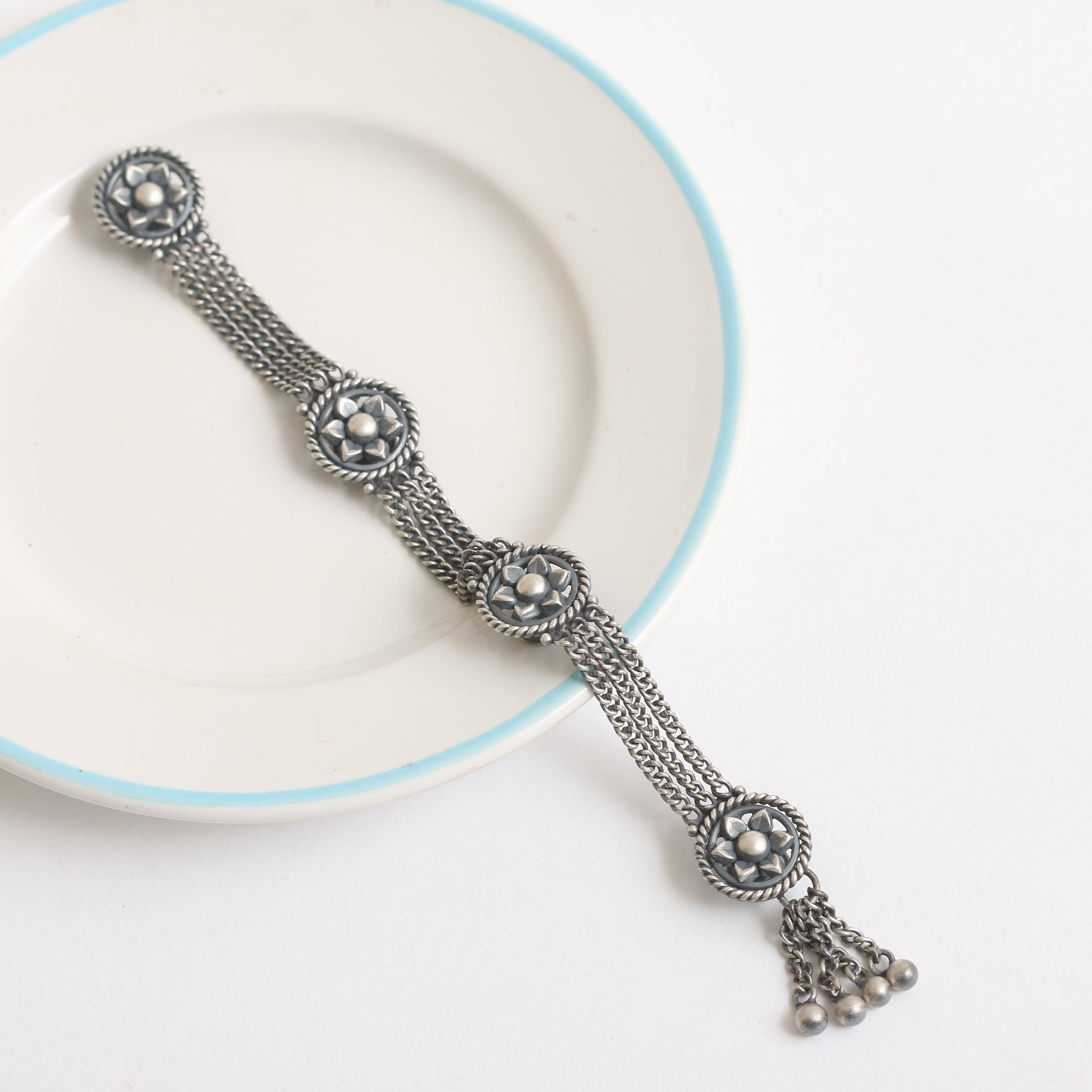 a white plate topped with a metal bracelet