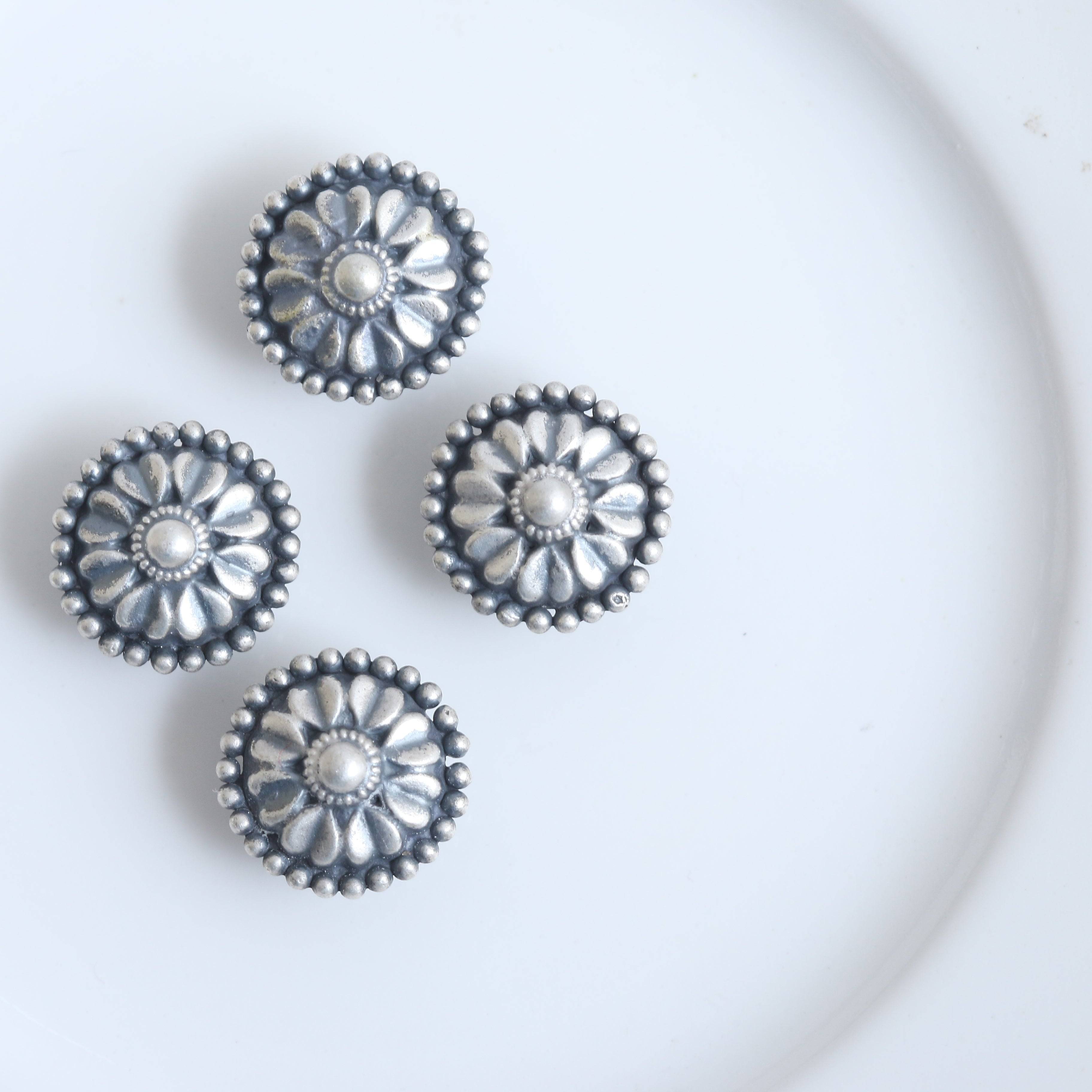 a white plate topped with three beaded flowers