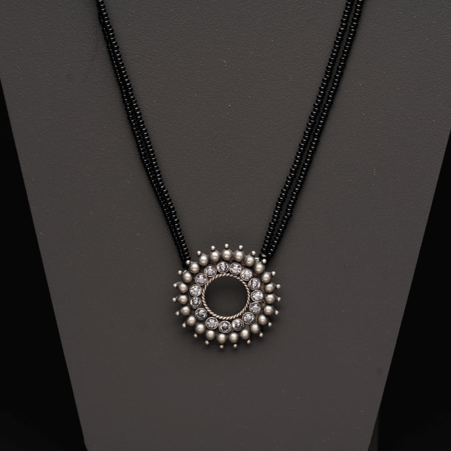 a necklace with beads and a circle pendant