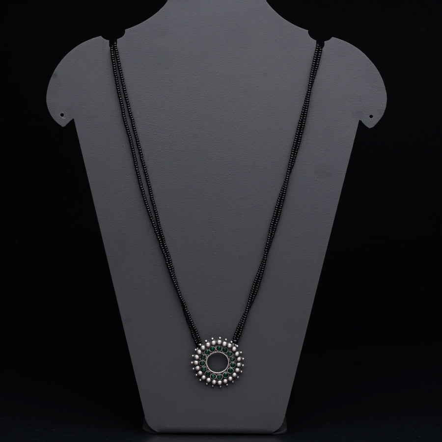a necklace on a mannequin with a black background