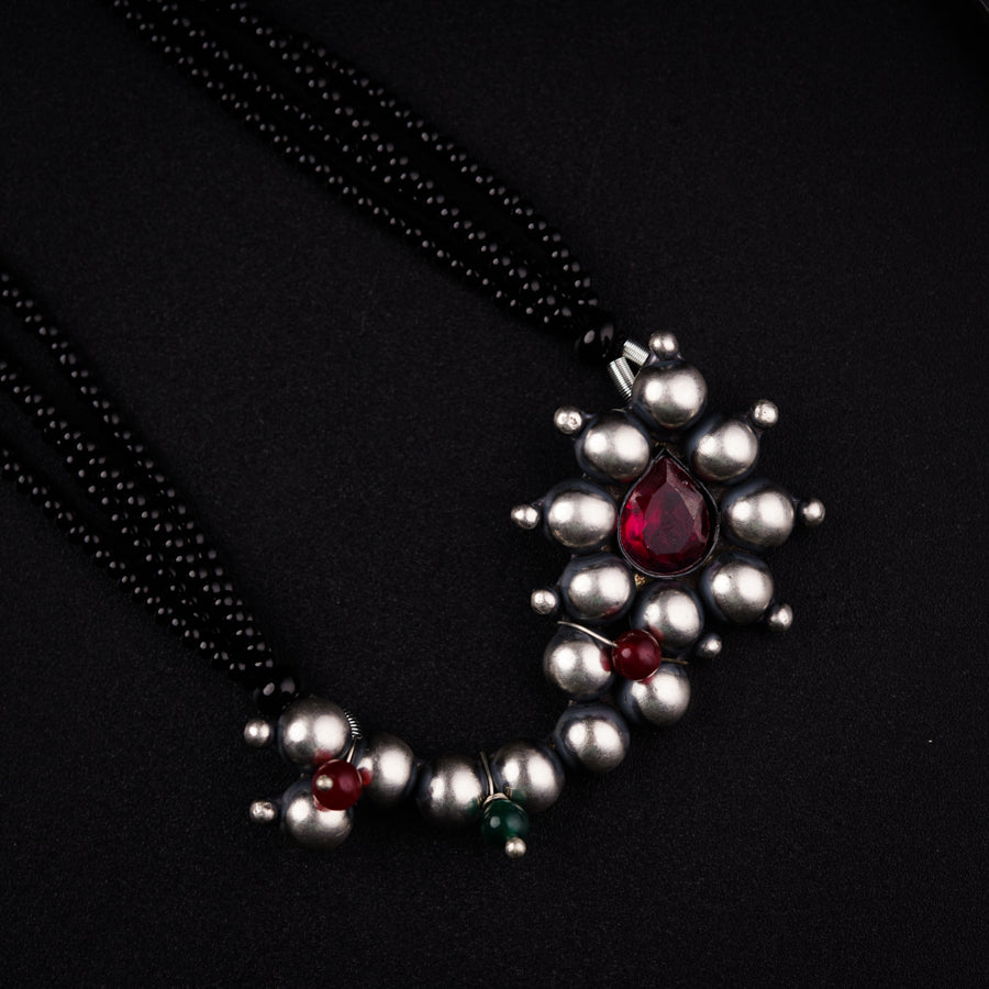 a close up of a necklace on a black surface