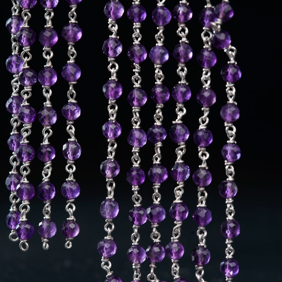 a bunch of purple beads hanging from a chain