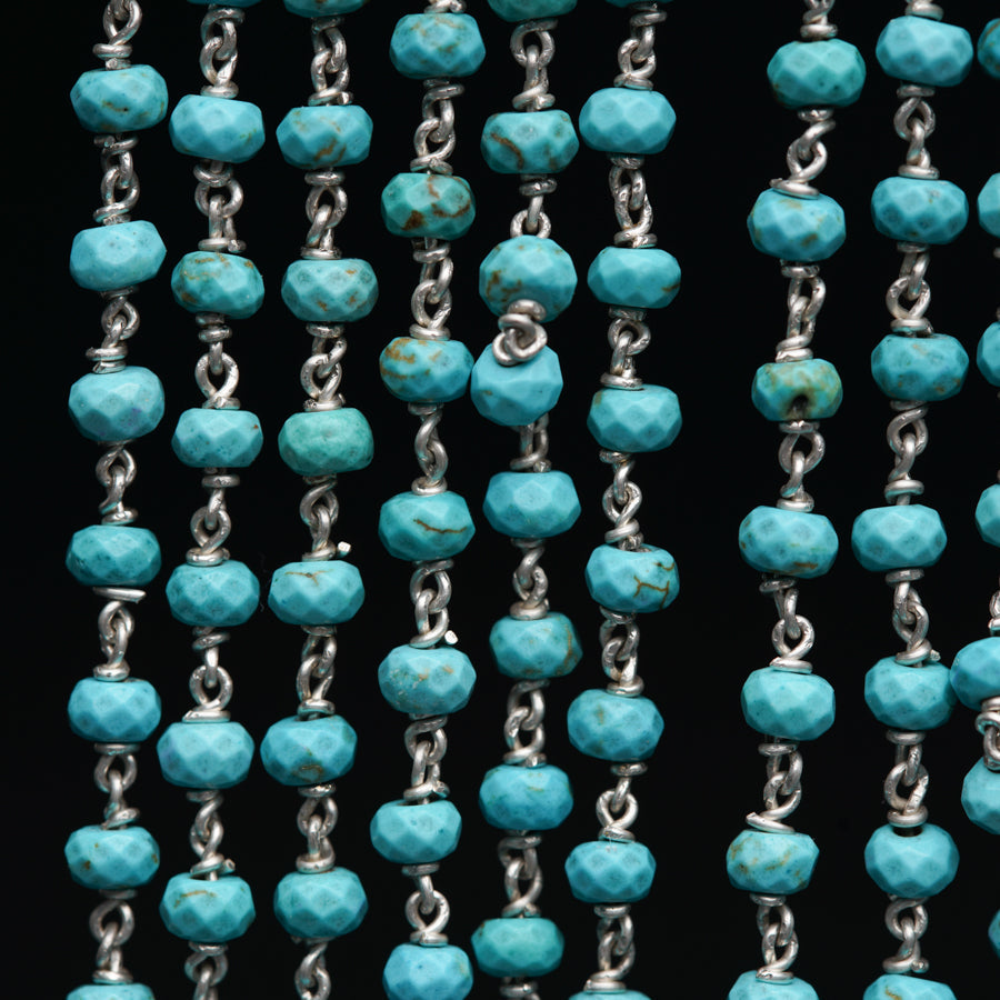 a close up of a chain of turquoise beads