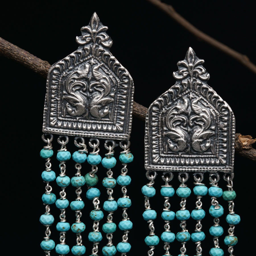 a pair of silver and turquoise beaded earrings
