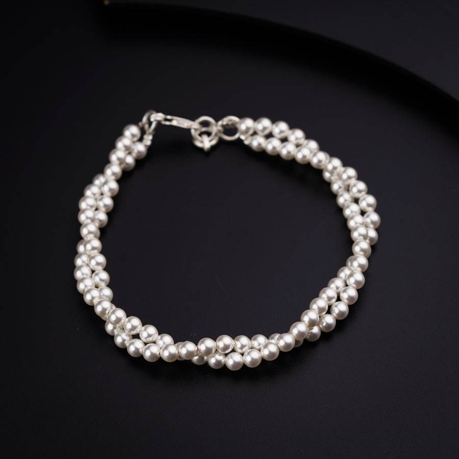 a single strand of white pearls on a black background