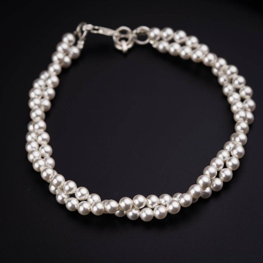 a close up of a bracelet with pearls