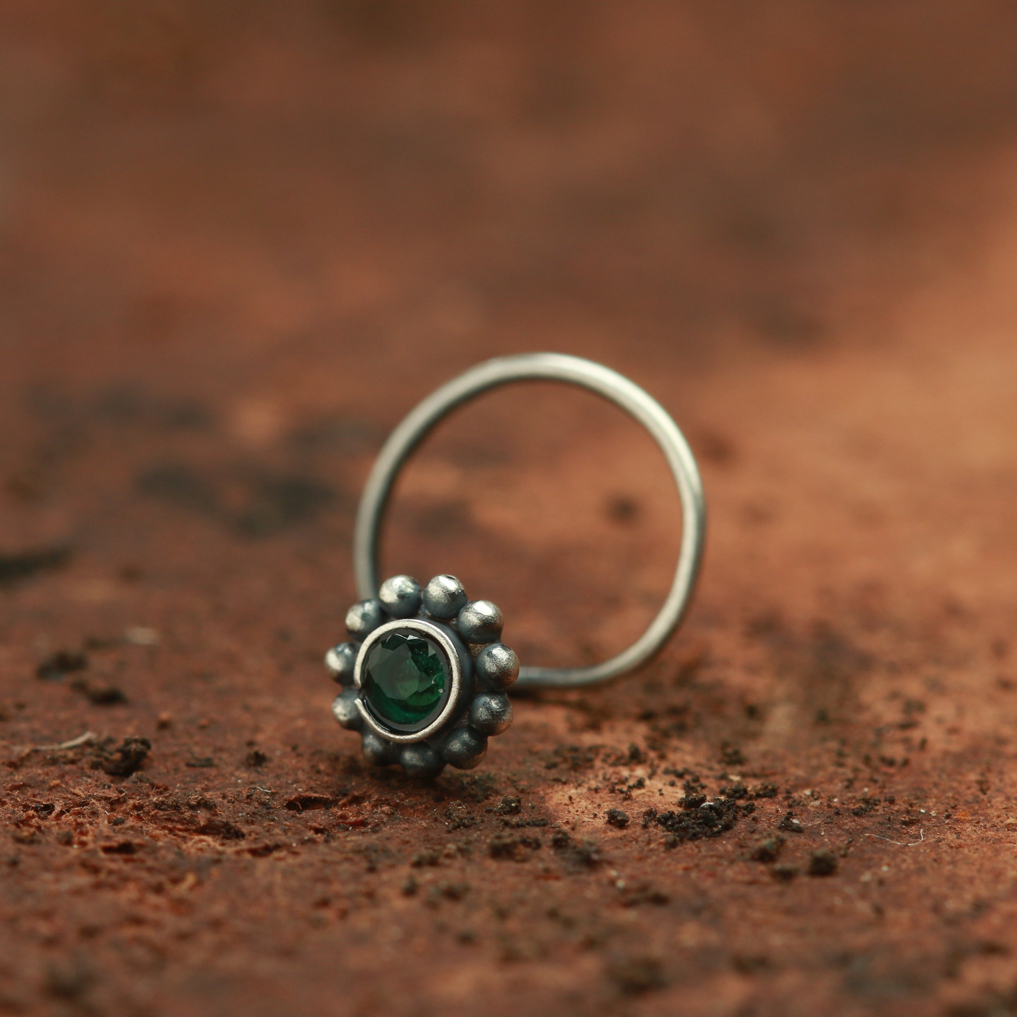 a close up of a ring with a green stone