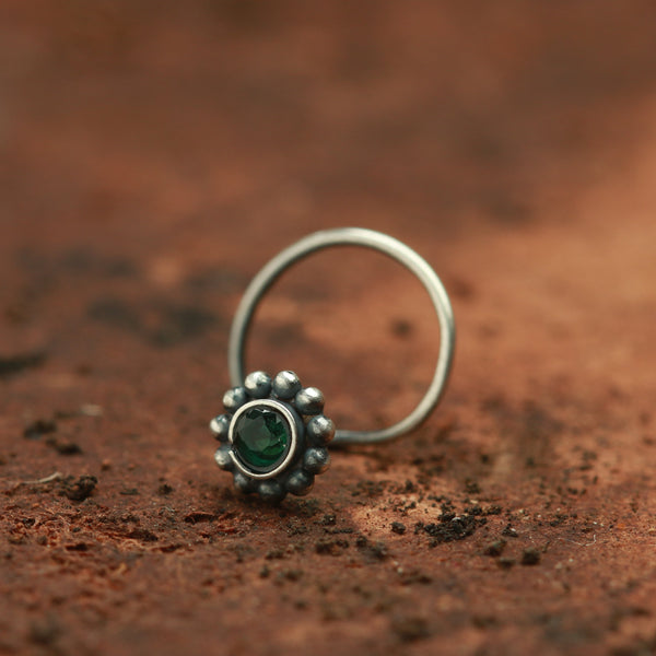 a close up of a ring with a green stone