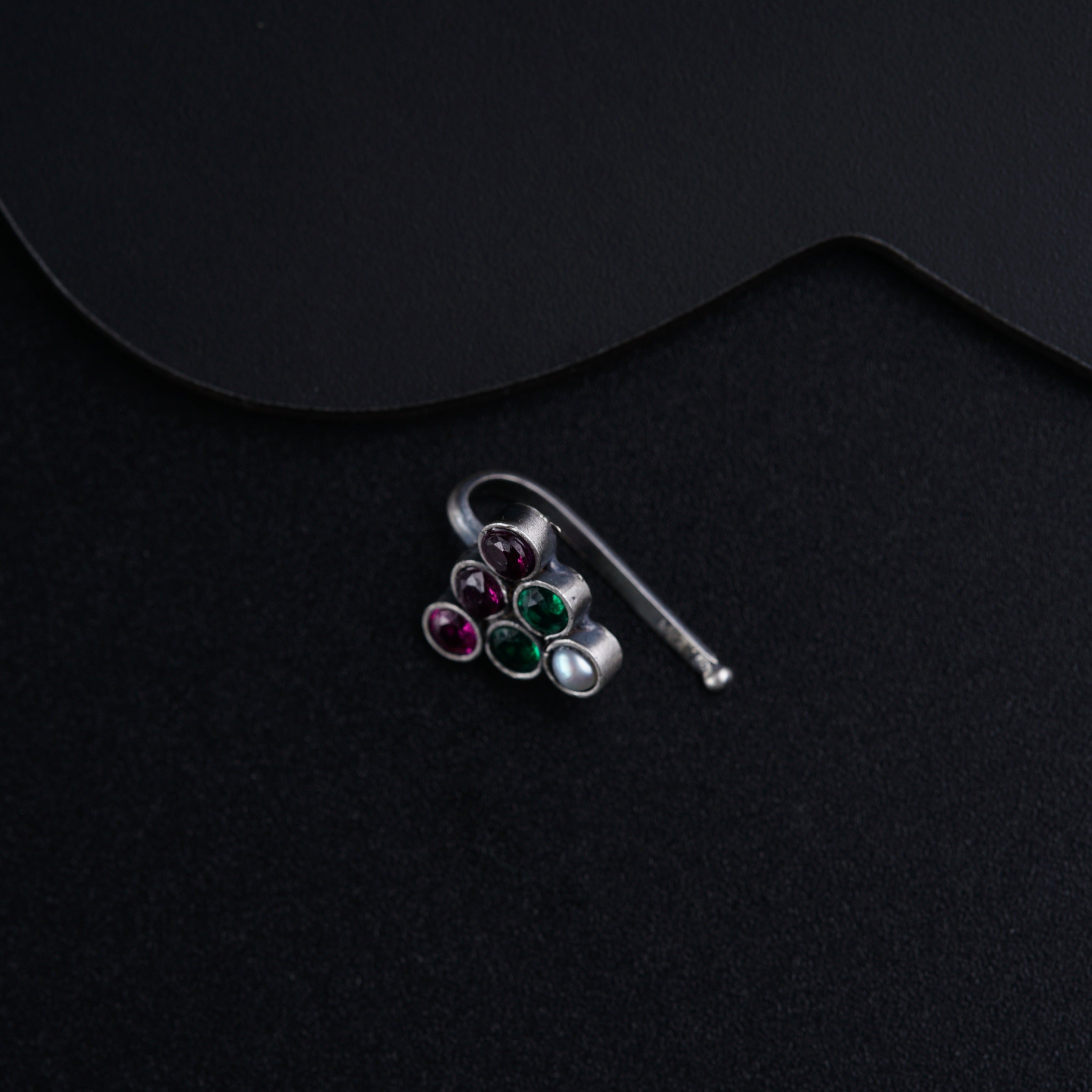 a pair of earrings sitting on top of a black surface
