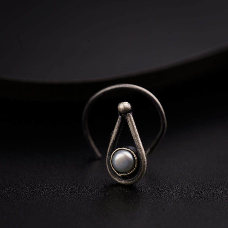a close up of a ring with a pearl on it