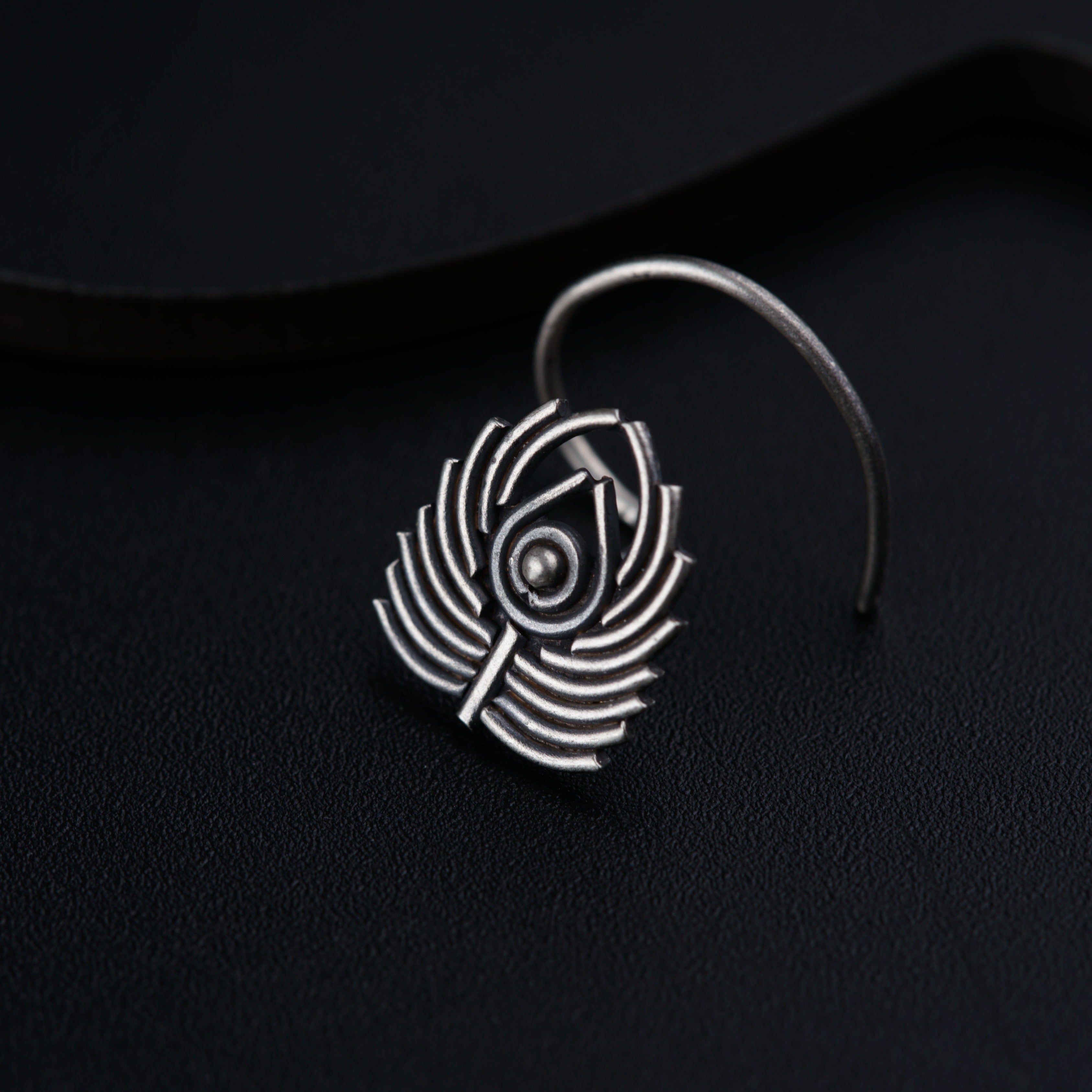 a close up of a pair of earrings on a black surface