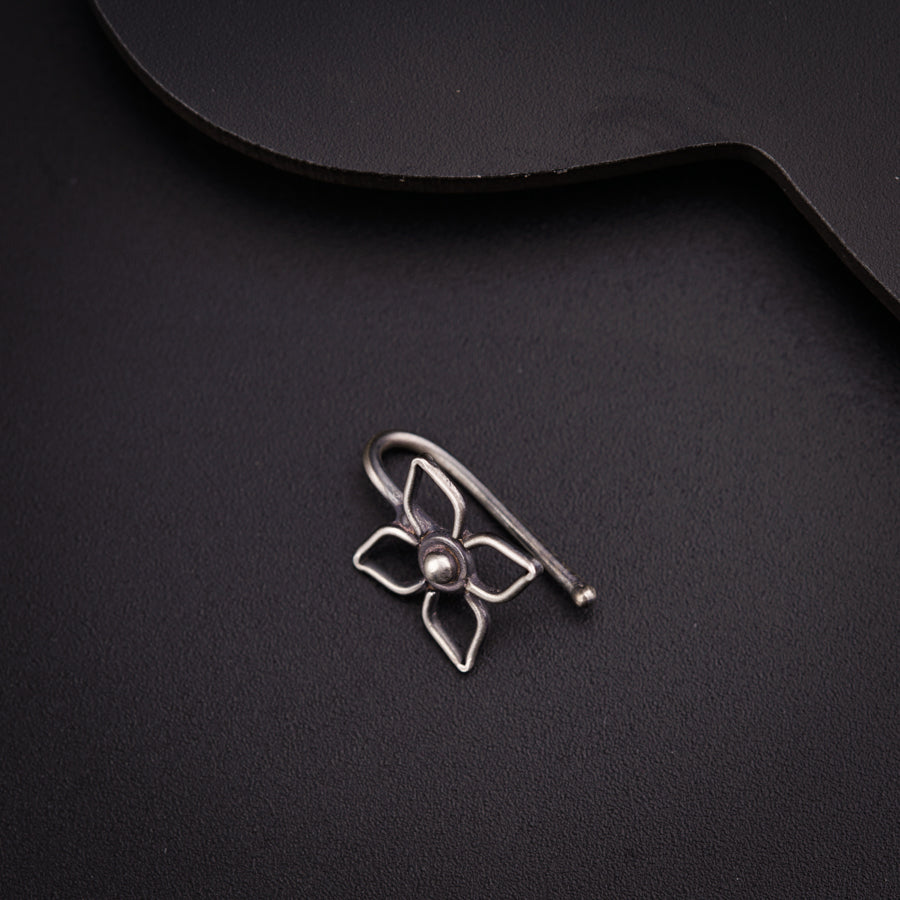 a silver brooch with a flower on it