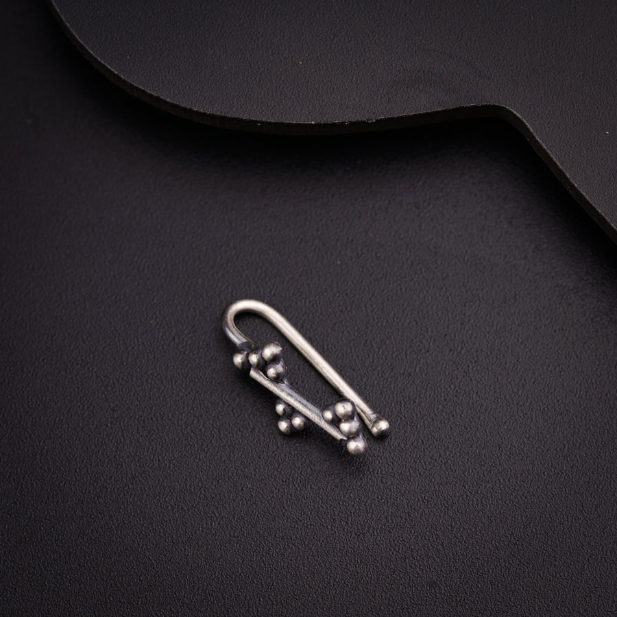 a pair of metal hooks sitting on top of a black surface