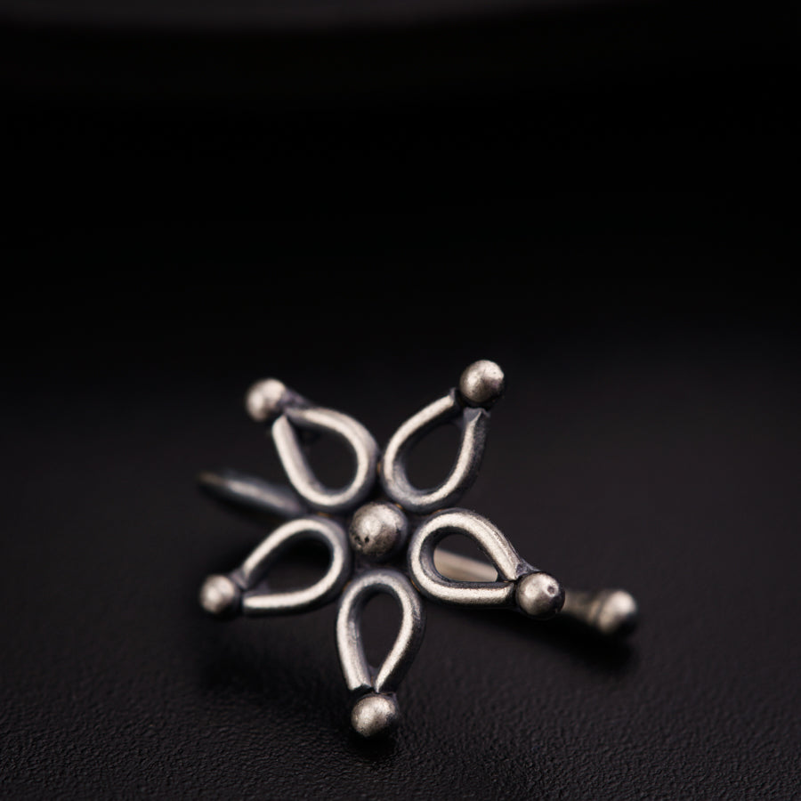 a silver snowflake sitting on top of a black surface