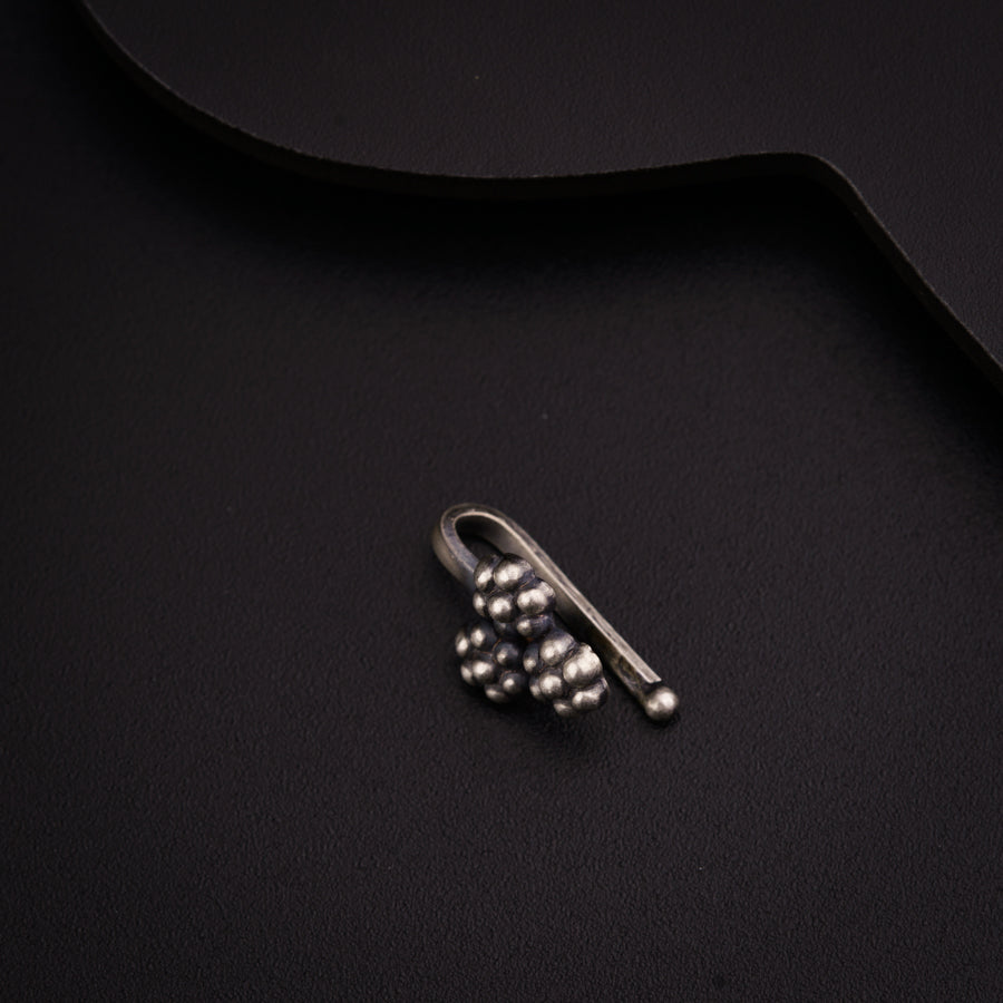 a pair of earrings sitting on top of a black surface