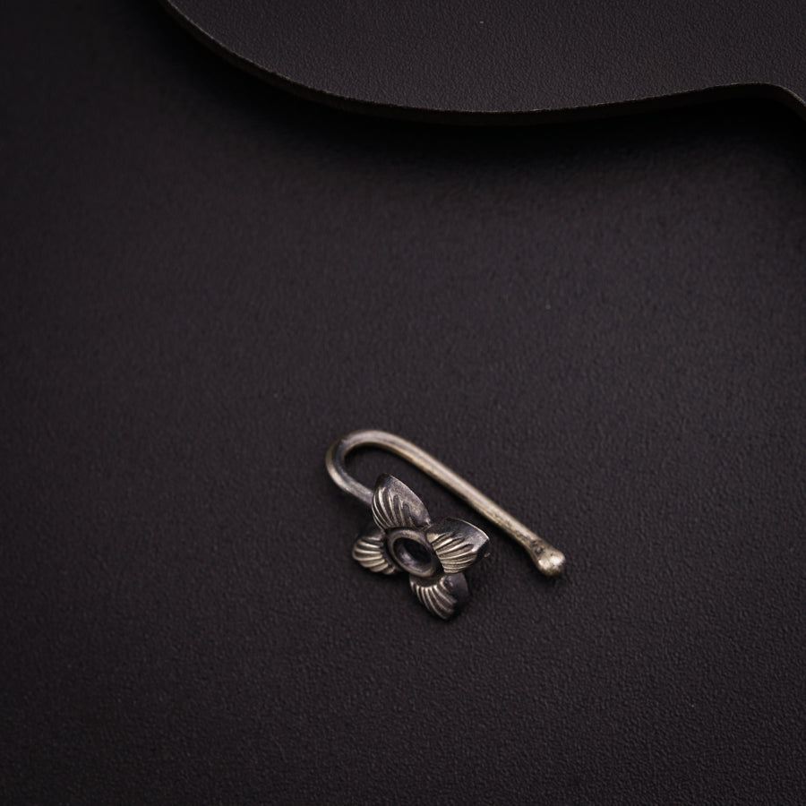 a metal hook with a flower on it