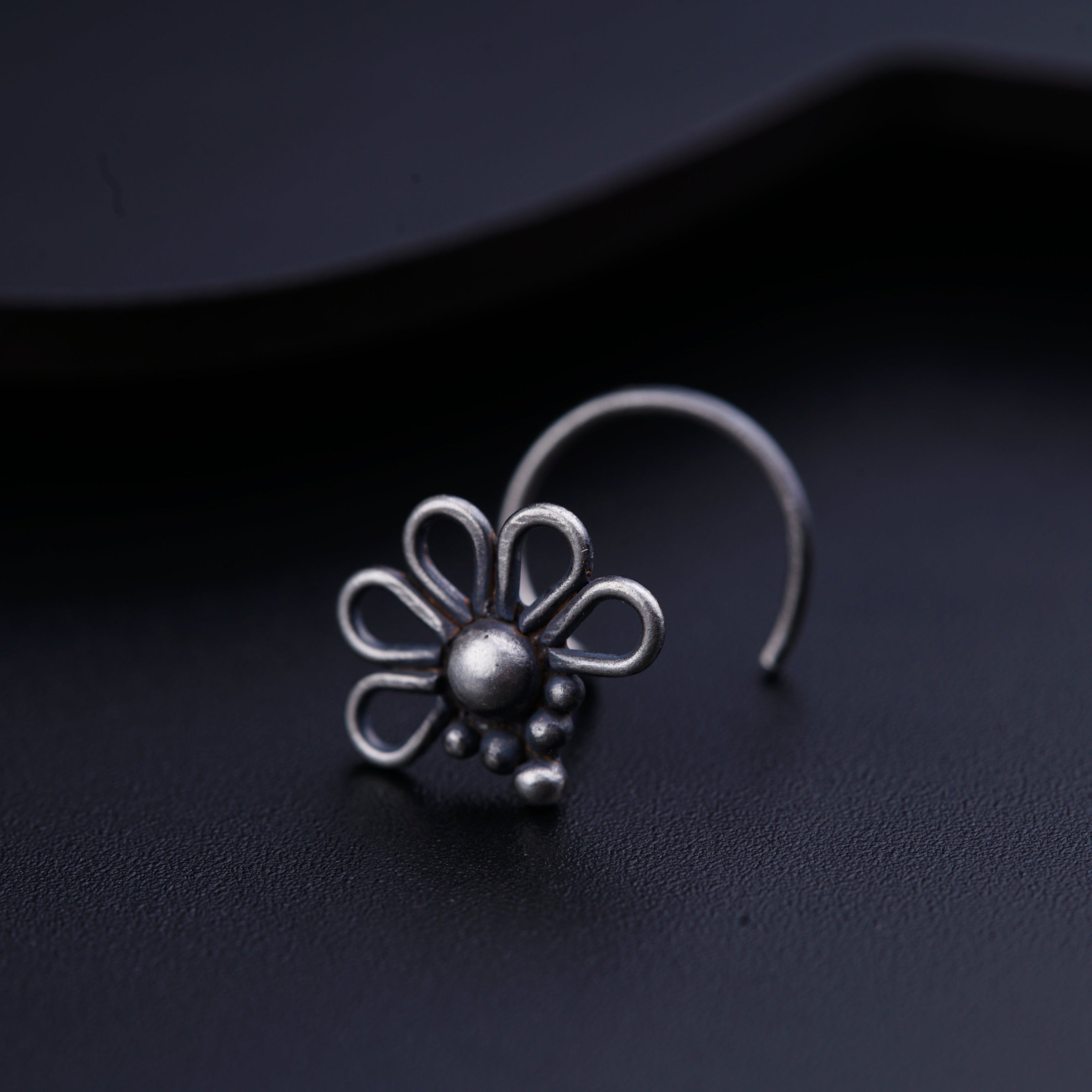 a close up of a pair of earrings on a black surface