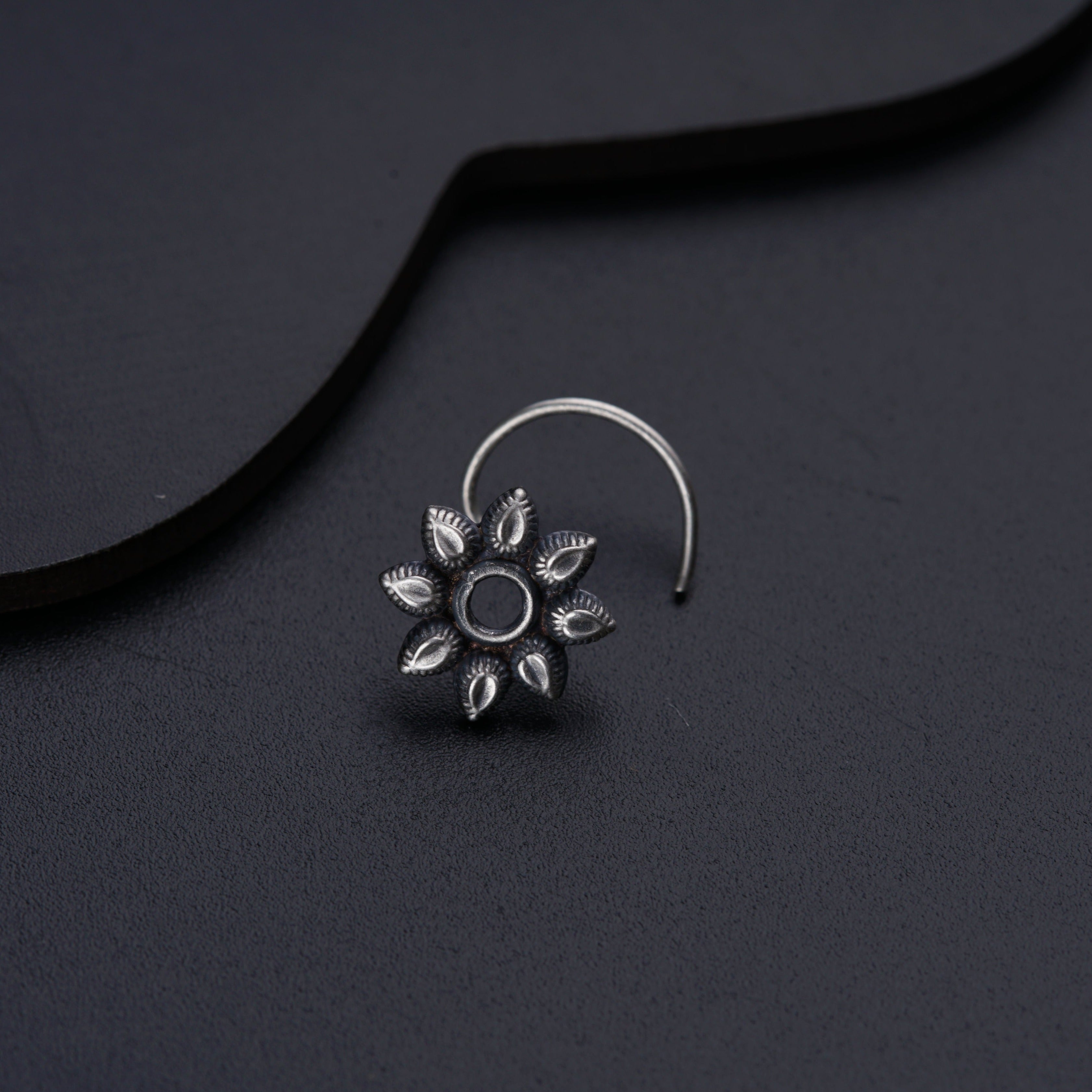 a close up of a pair of earrings on a black surface