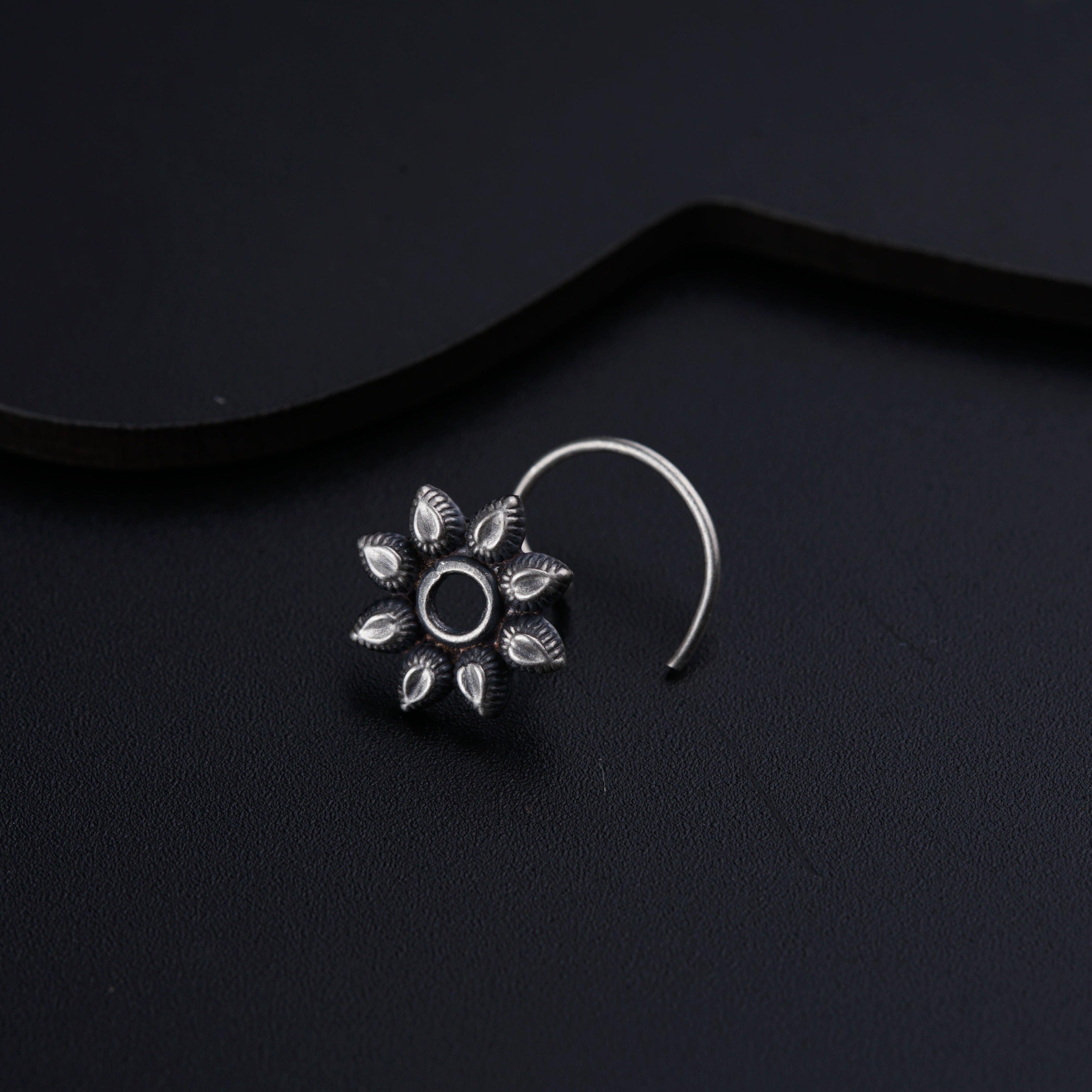 a close up of a pair of earrings on a black surface