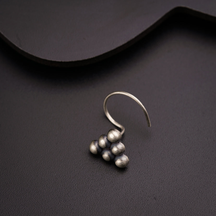a pair of silver earrings sitting on top of a table