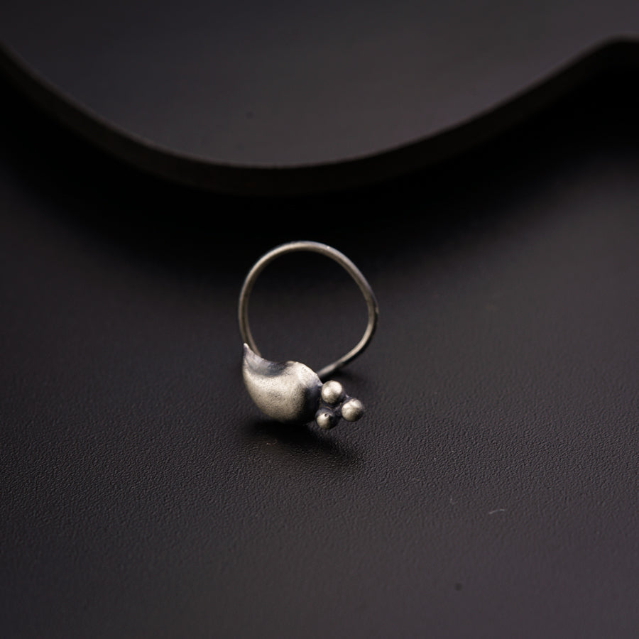 a close up of a silver ring on a black surface