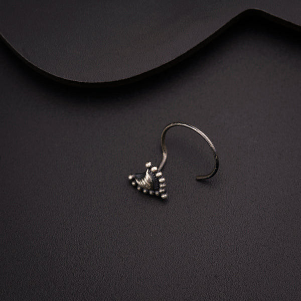 a pair of silver earrings sitting on top of a black surface