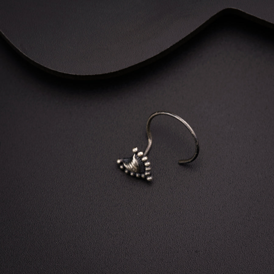 a pair of silver earrings sitting on top of a black surface