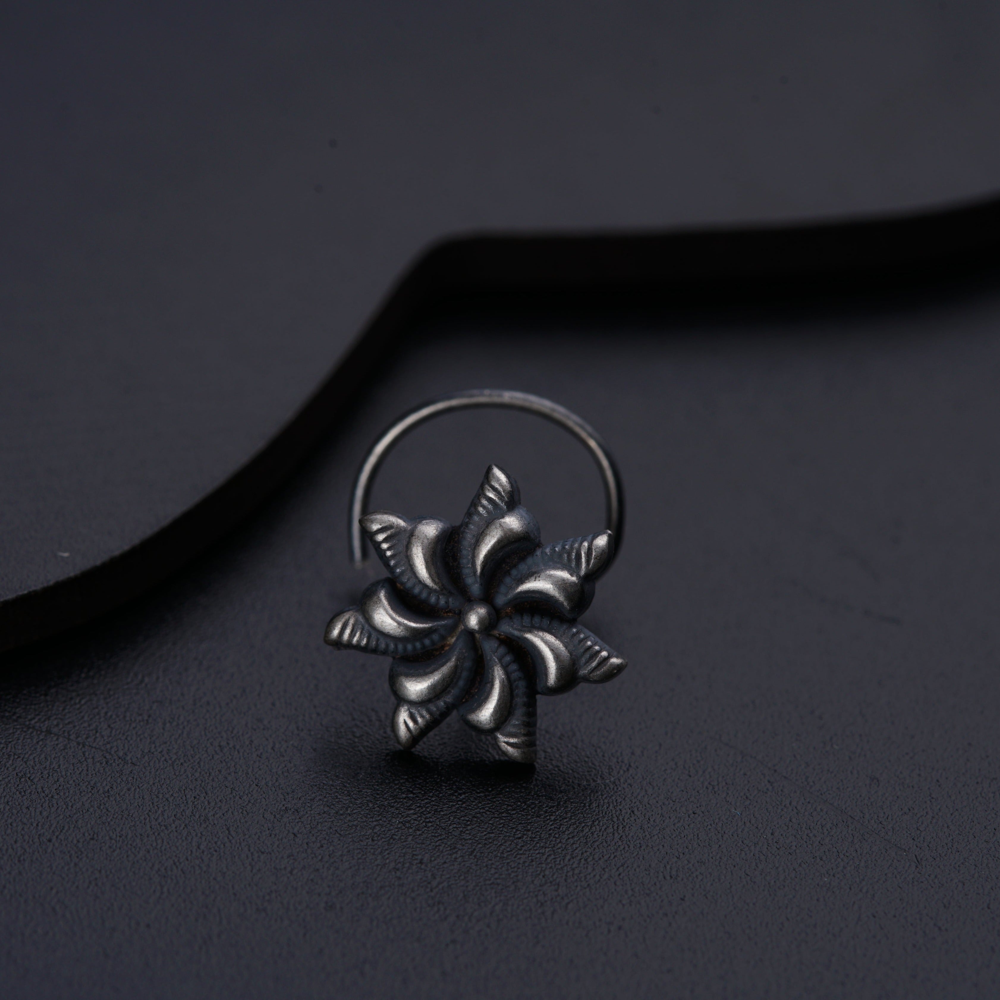 a silver ring with a flower design on it