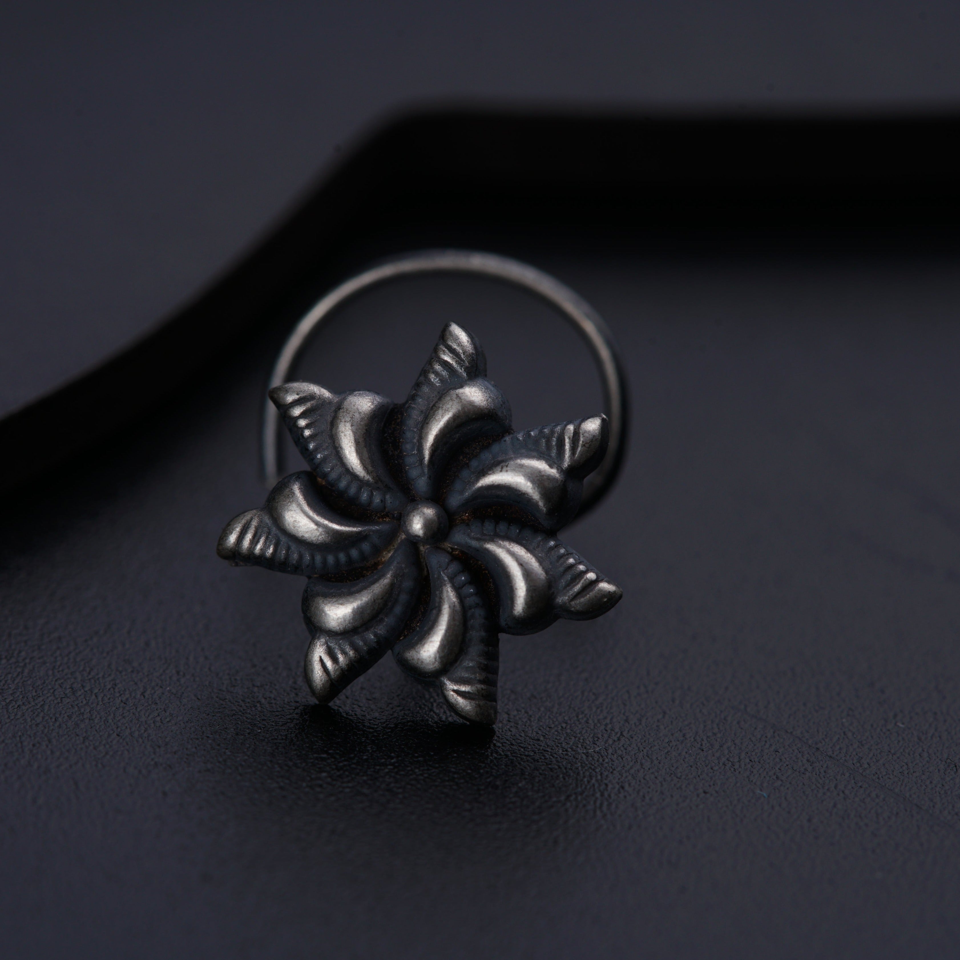 a silver ring with a flower design on it