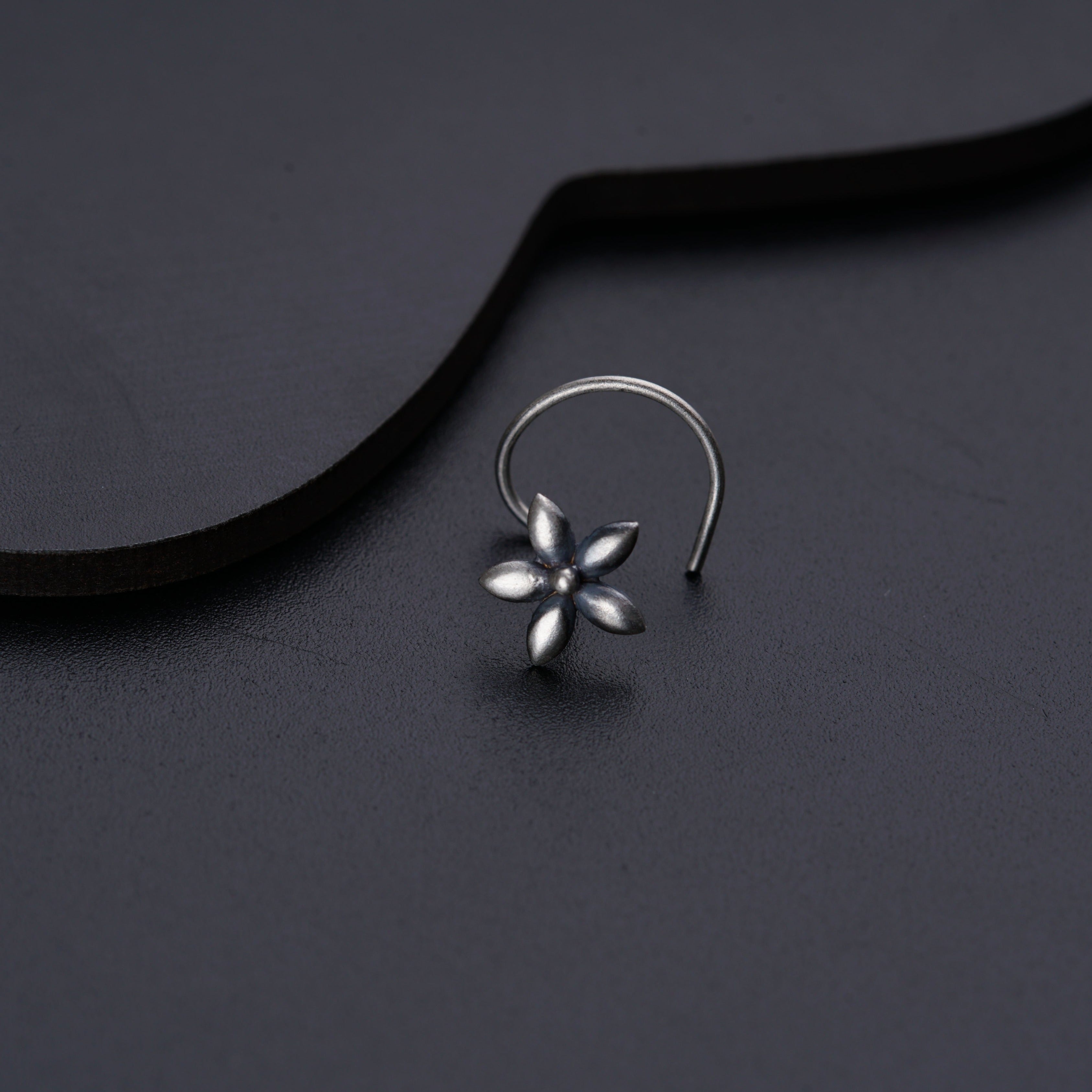 a close up of a pair of earrings on a black surface