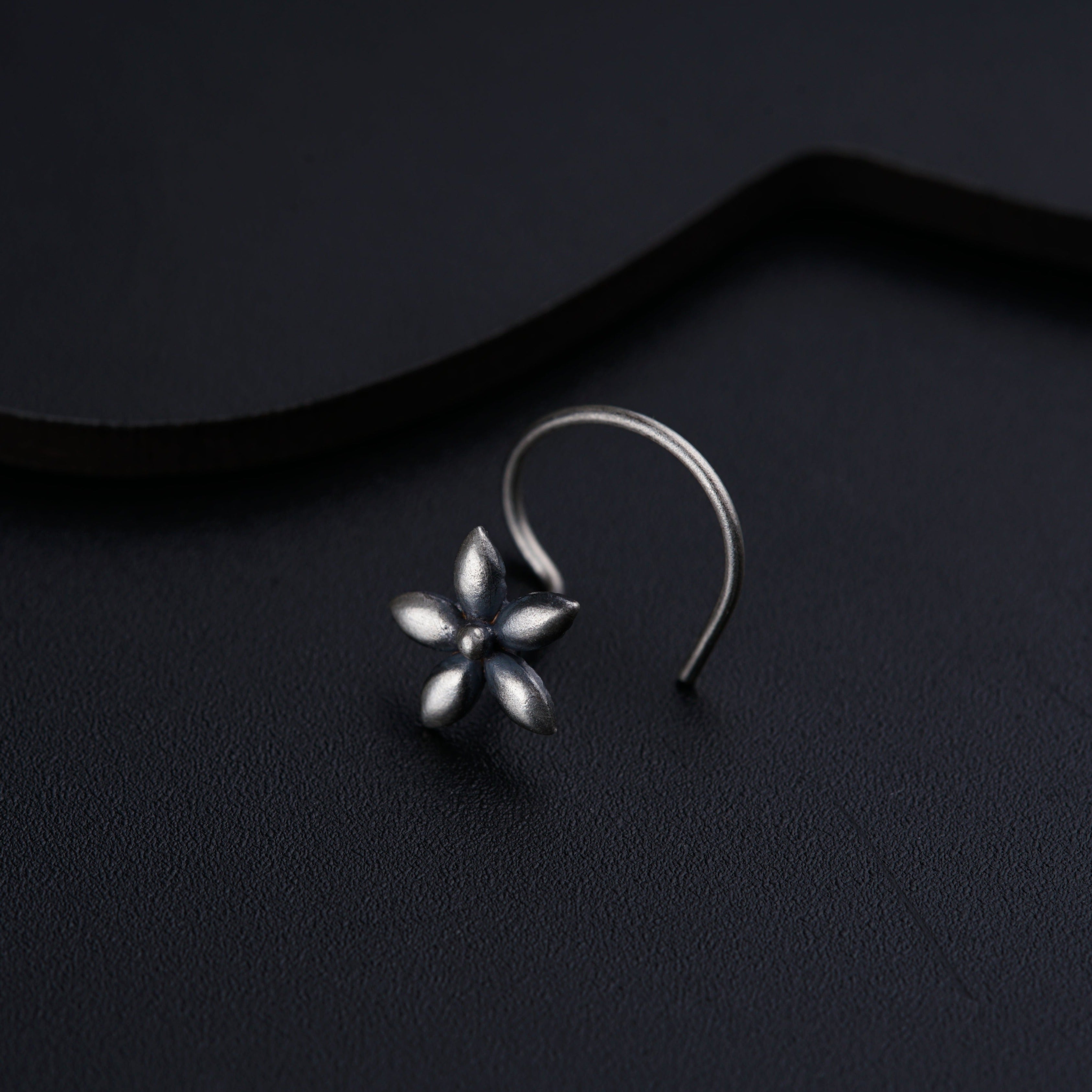 a close up of a pair of earrings on a black surface