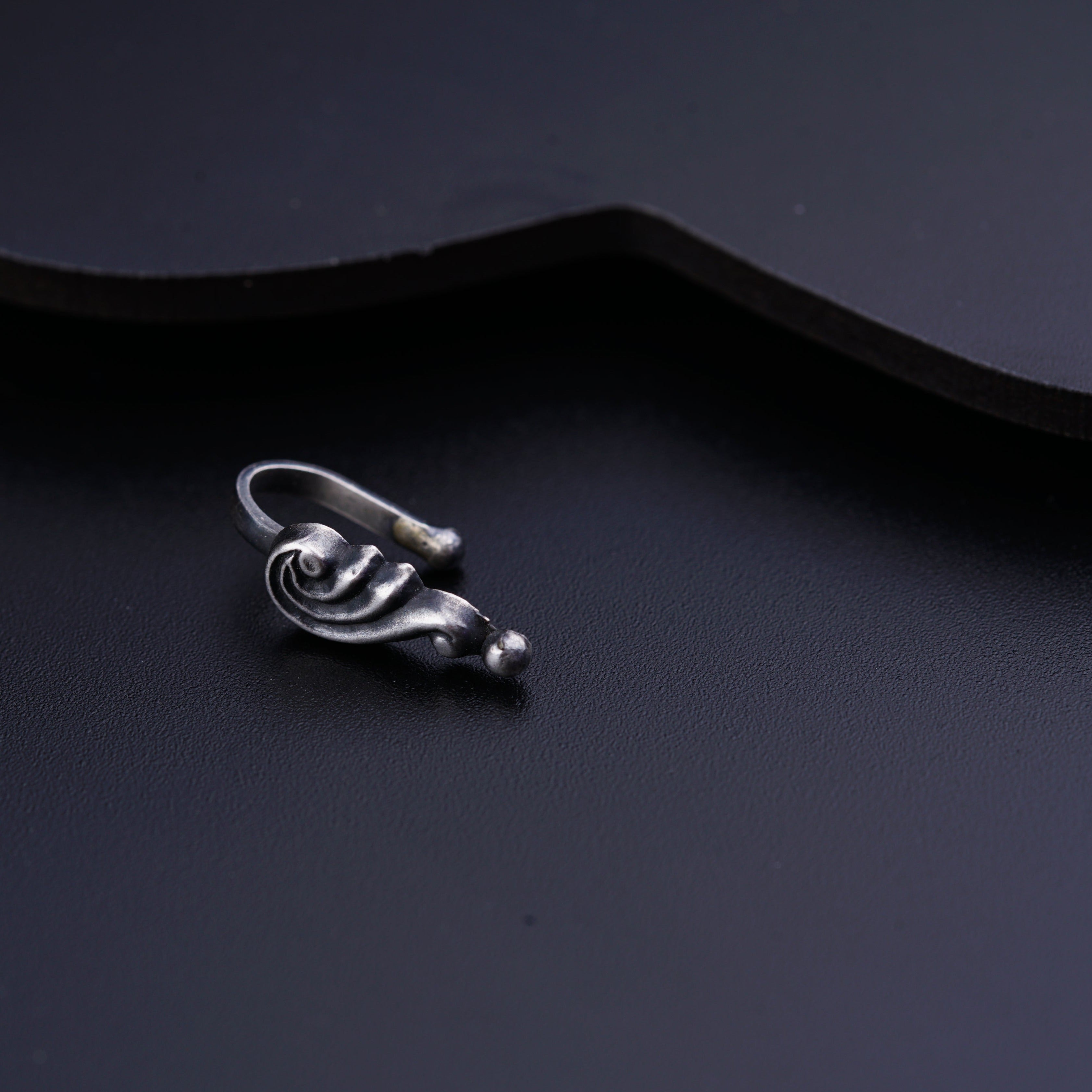 a close up of a metal object on a black surface