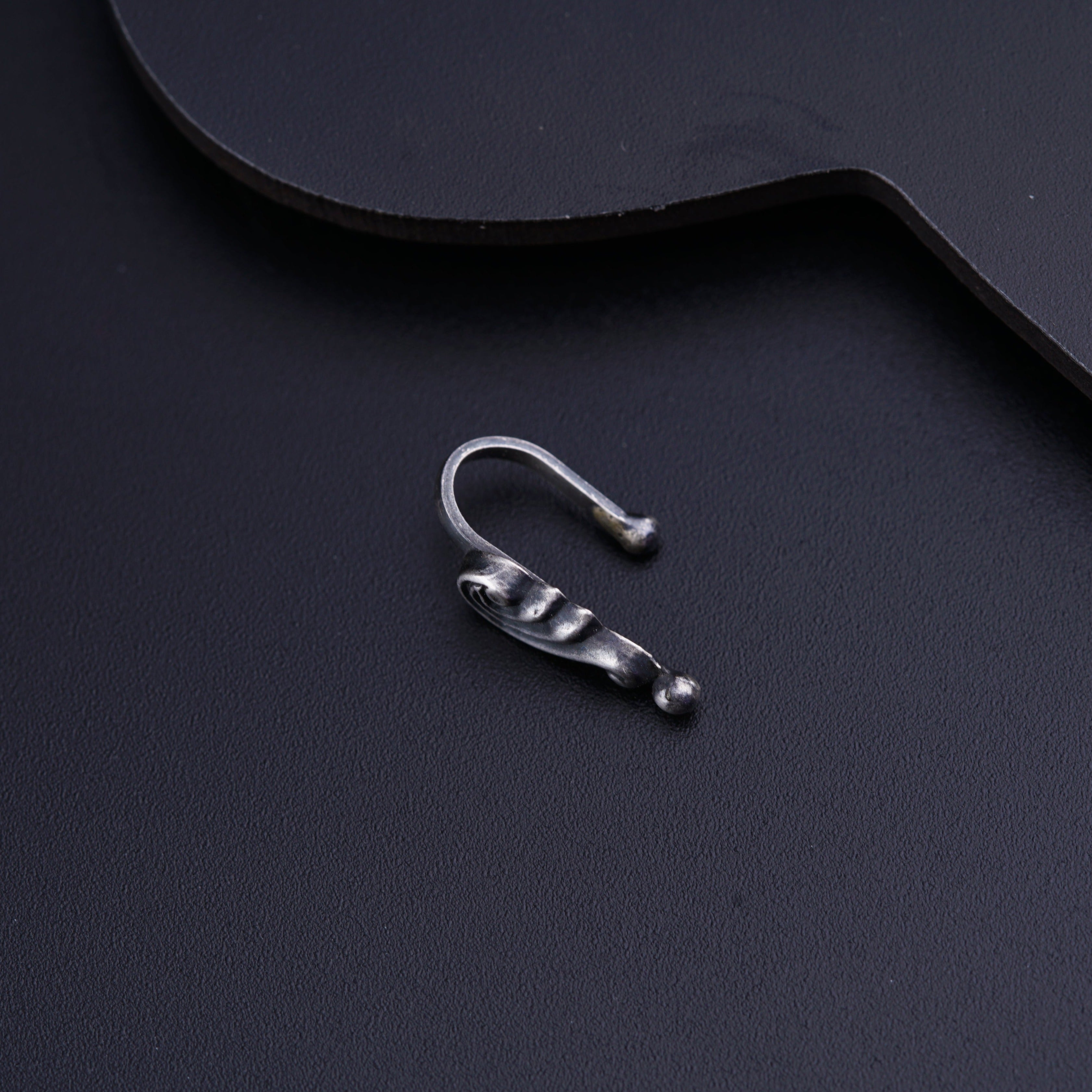 a pair of silver ear clips sitting on top of a guitar