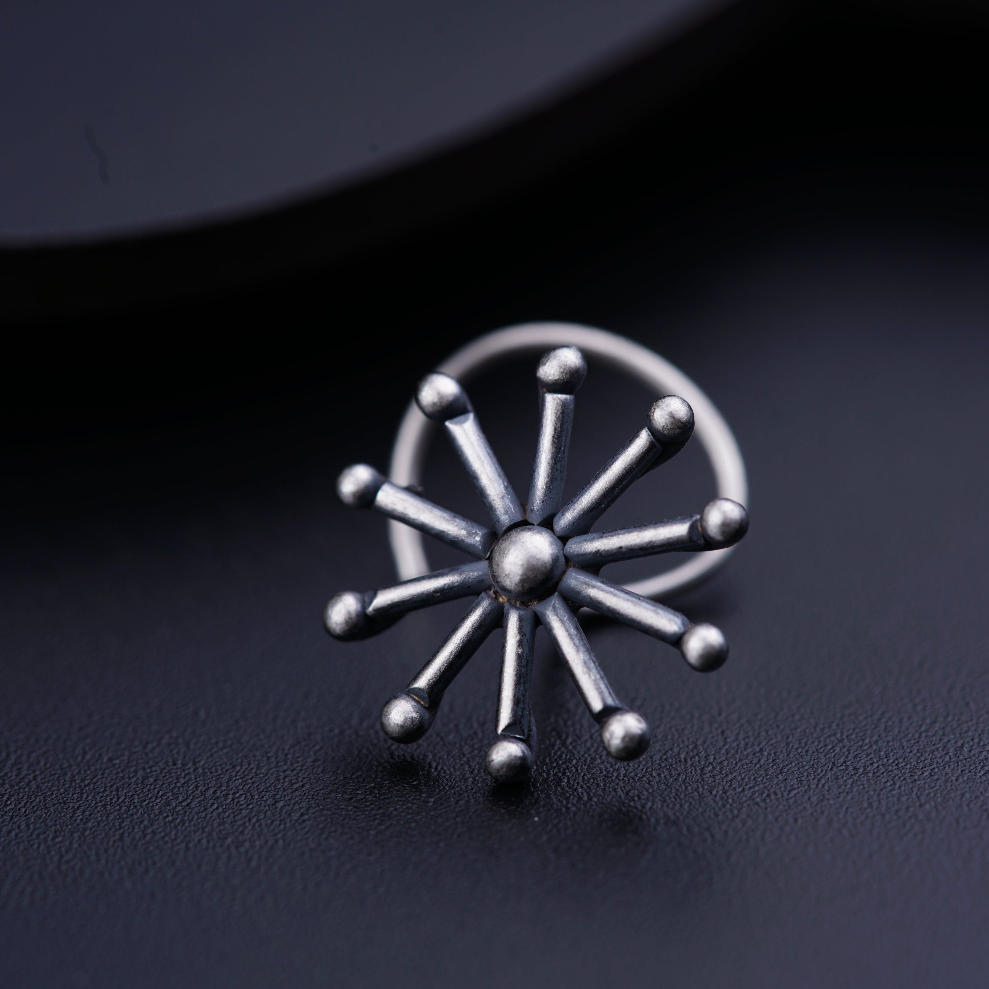 a close up of a metal object on a black surface