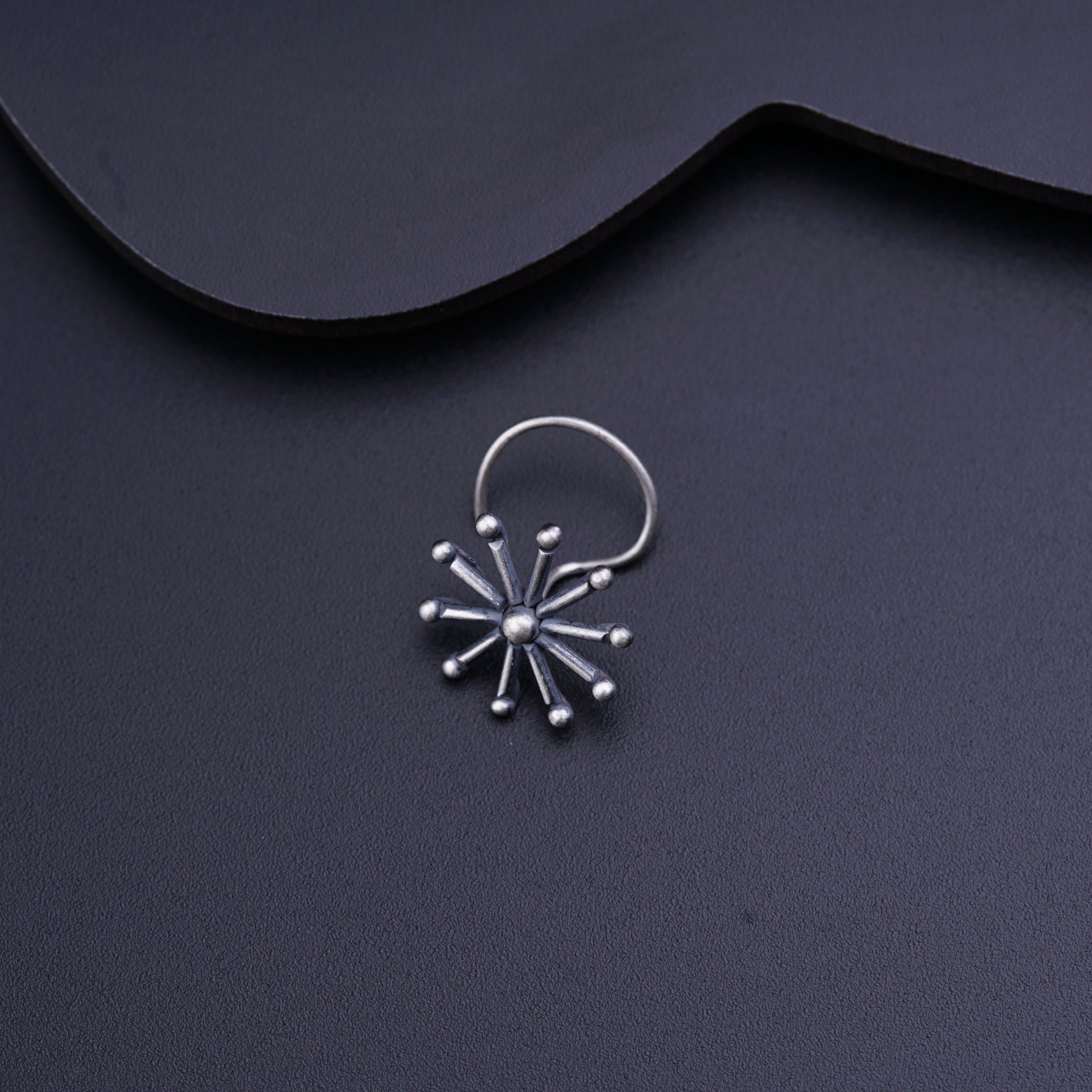 a pair of silver hoop earrings on a black surface