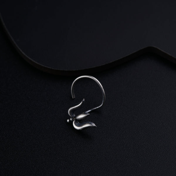 a pair of silver earrings on a black surface