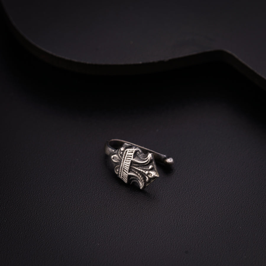 a silver ring sitting on top of a black surface