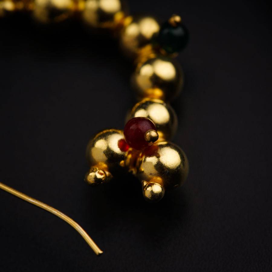 a close up of a gold necklace with beads