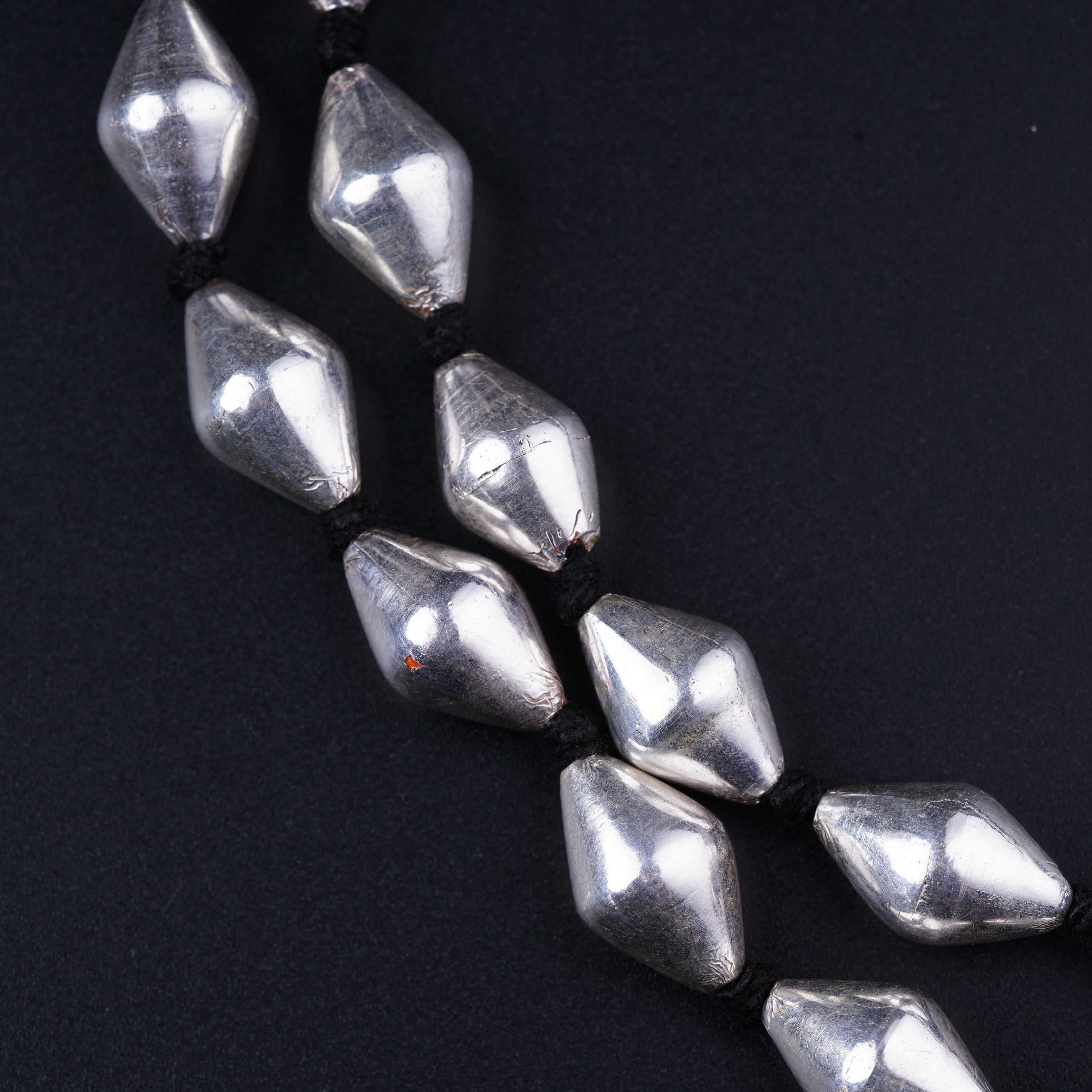 a close up of a bunch of beads on a black surface