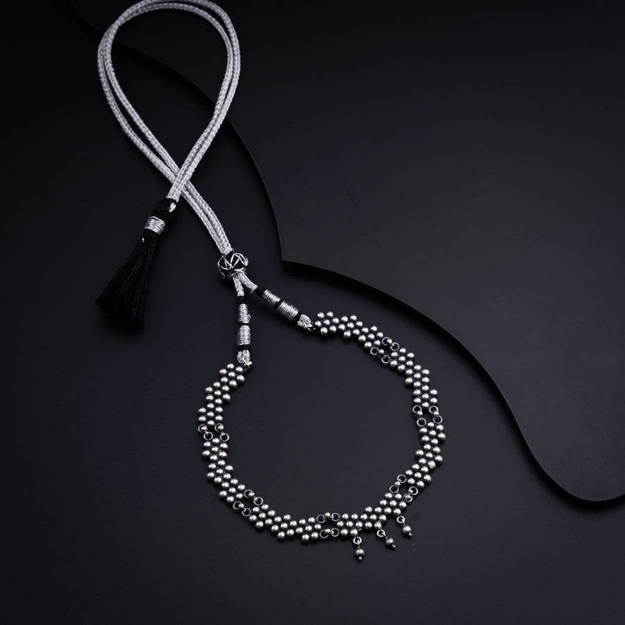 a black and white beaded necklace with a tassel