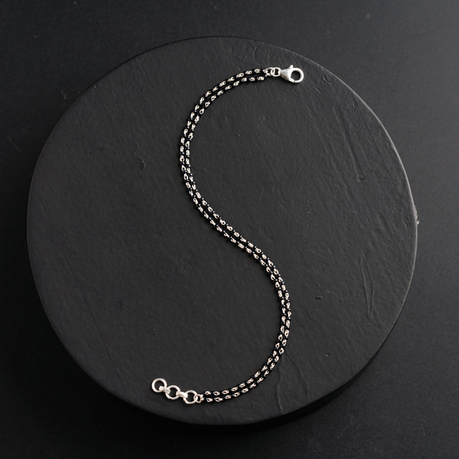 a silver chain with a clasp on a black background